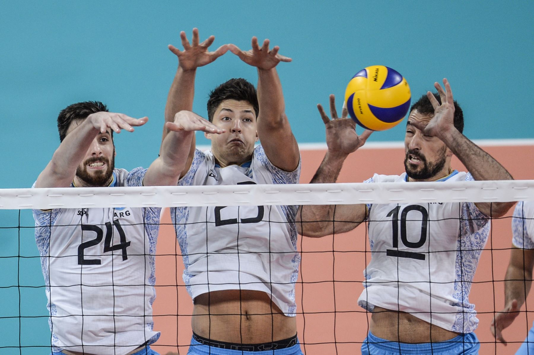 El argentino Johansen (L), Joaquín Gallego (C) y Nicolás Bruno saltan para bloquear el balón durante las finales de voleibol masculino en los Juegos Panamericanos de Lima 2019 en el Estadio Miguel Grau. AFP