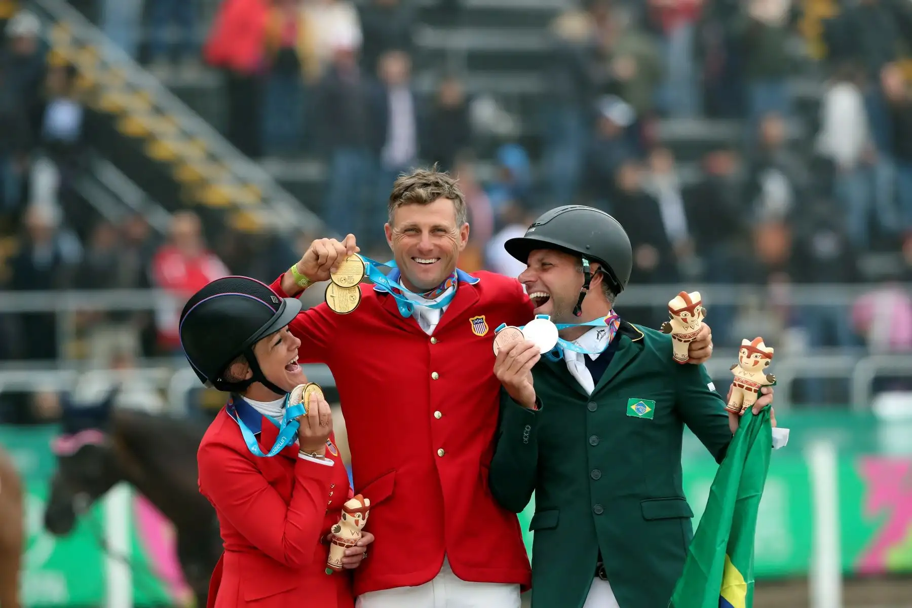 Body Martin (c) de Estados Unidos, medalla de oro, Lynn Symansky (i) de Estados Unidos, plata, y Carlos Parro de Brasil, bronce, celebran este sábado en la premiación del concurso completo individual en los Juegos Panamericanos Lima  2019. EFE