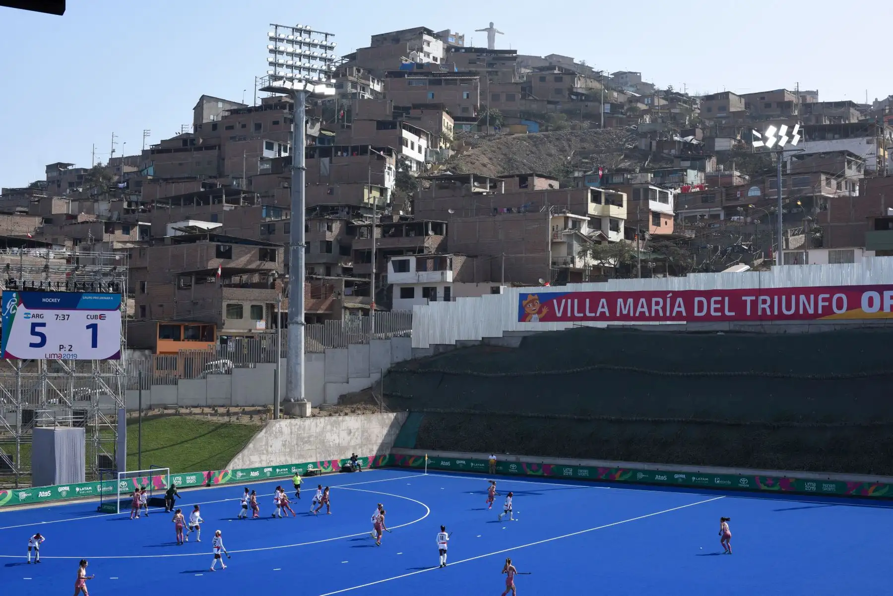Hockey femenino sobre césped sintético. Encuentro entre Argentina y Chile. En contraste de fondo, una ladera de un cerro poblado de casas en la zona de Villa Maria del Truinfo (periferia de Lima). Lugar: Complejo Deportivo Villa María del Triunfo. Foto: ANDINA/ Lima 2019