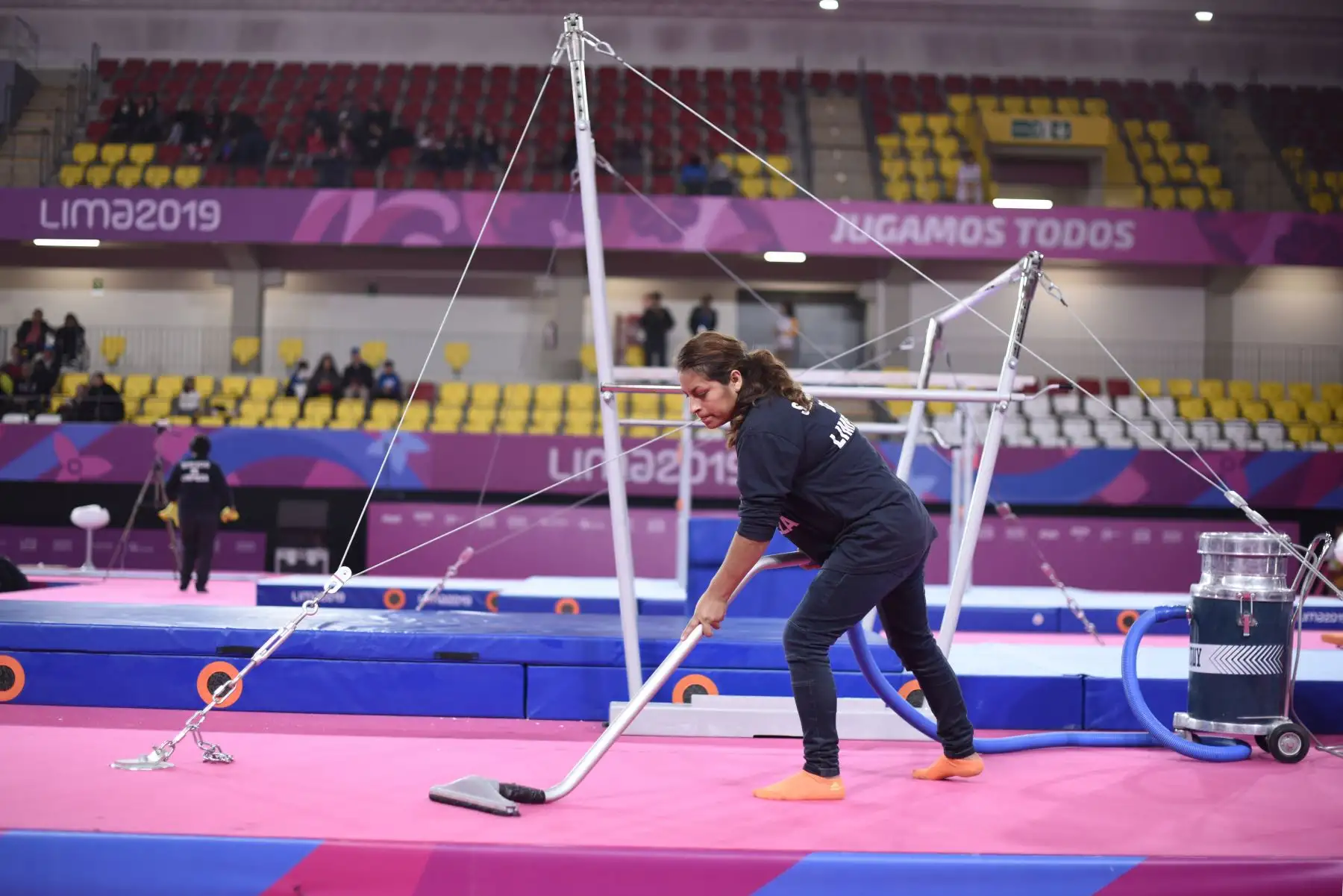 Una trabajadora lustra el piso alfombrado para uno de los eventos de Gimnasia Artística en el Polideportivo Villa el Salvador. Foto: ANDINA/ Lima 2019