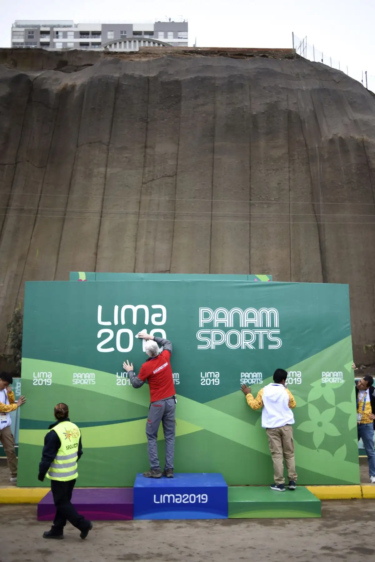 Personal de Lima 2019 limpiando el cartel de los paramericanos previa a la entrega de medallas de Ciclismo de Ruta realizada en la costa verde. Foto: ANDINA/ Lima 2019