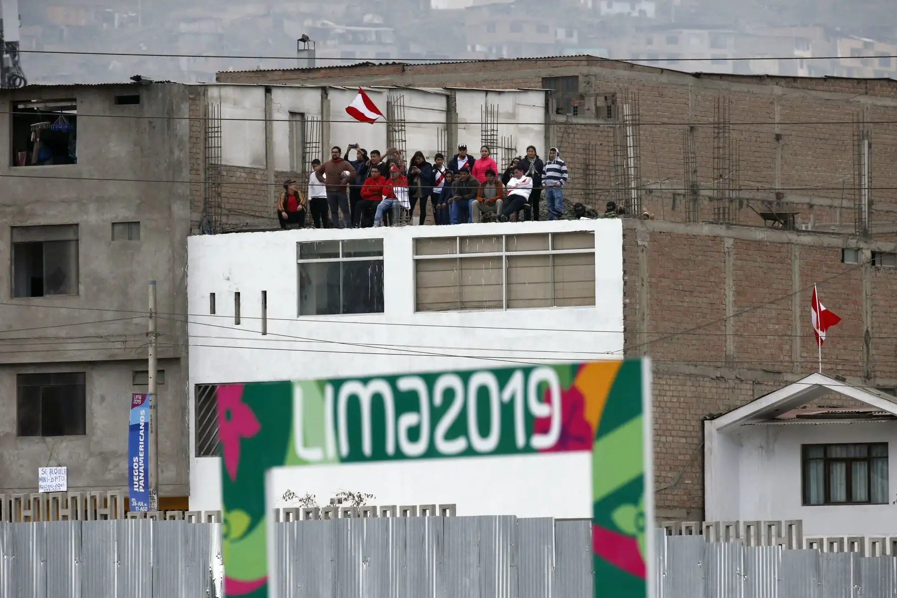 En el techo de una casa de los al rededores del Complejo deportivo Villa Maria del Triunfo, en pleno 28 de Julio, una familia se reúne para presenciar el partido final de Rugby Sevens femenino y masculino. Foto: ANDINA/ Lima 2019