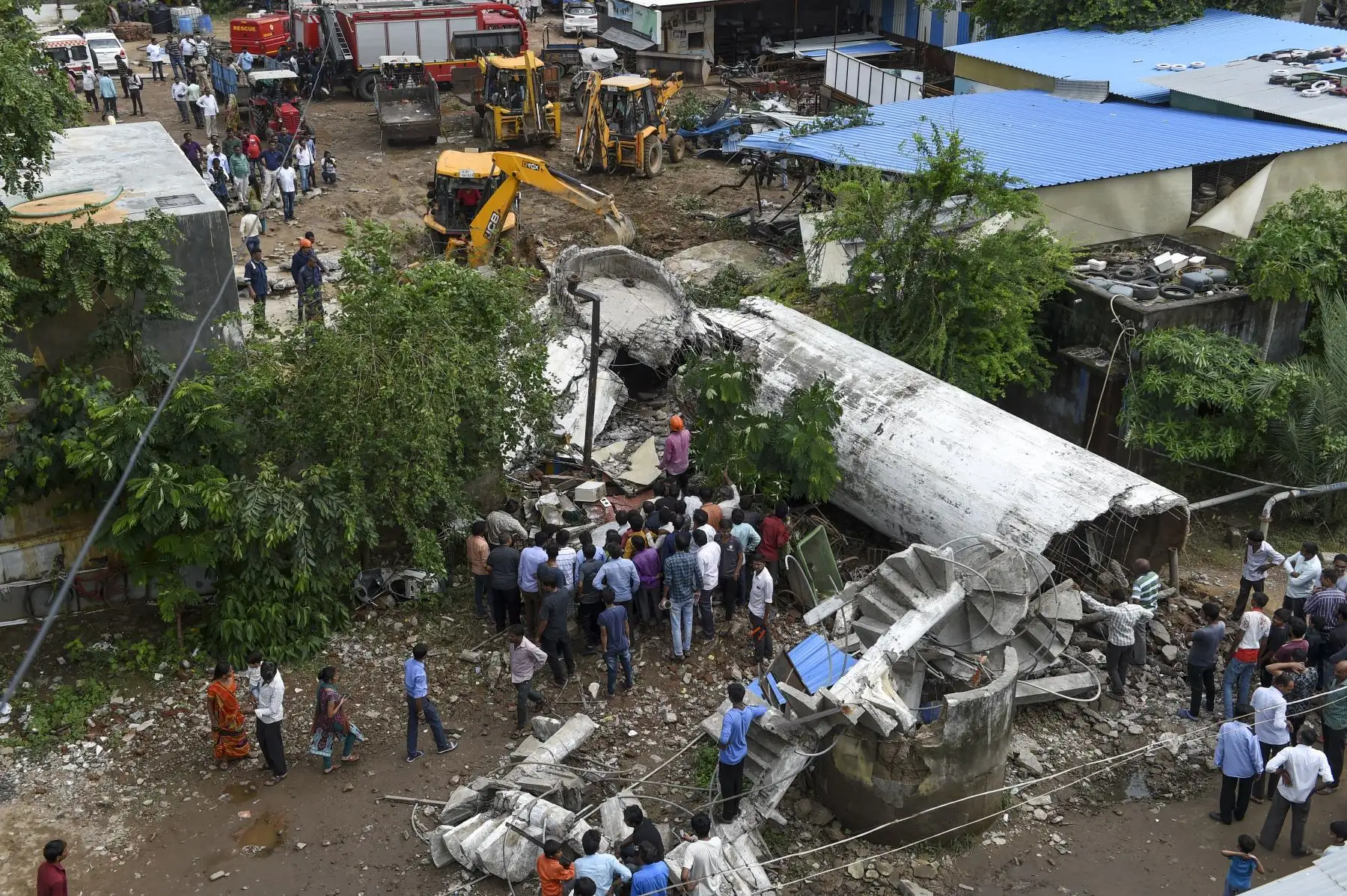 Residentes reunidos mientras los rescatistas buscan a los sobrevivientes después de que un tanque de agua se derrumbó por las fuertes lluvias en Ahmedabad. AFP