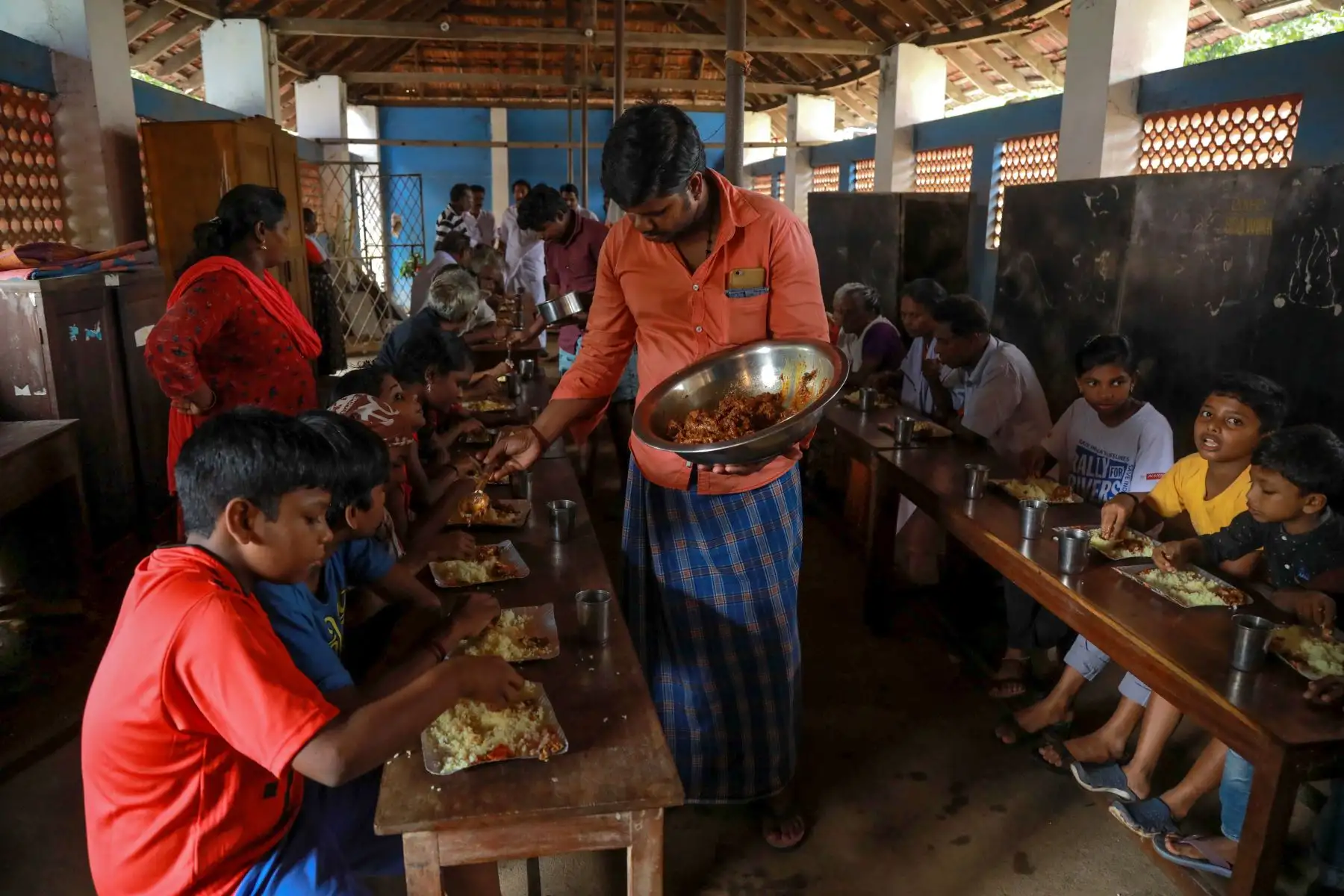 A las personas desplazadas por la inundaciones se les sirve comida en un campamento de ayuda en Kunnukara al sur de India. AFP