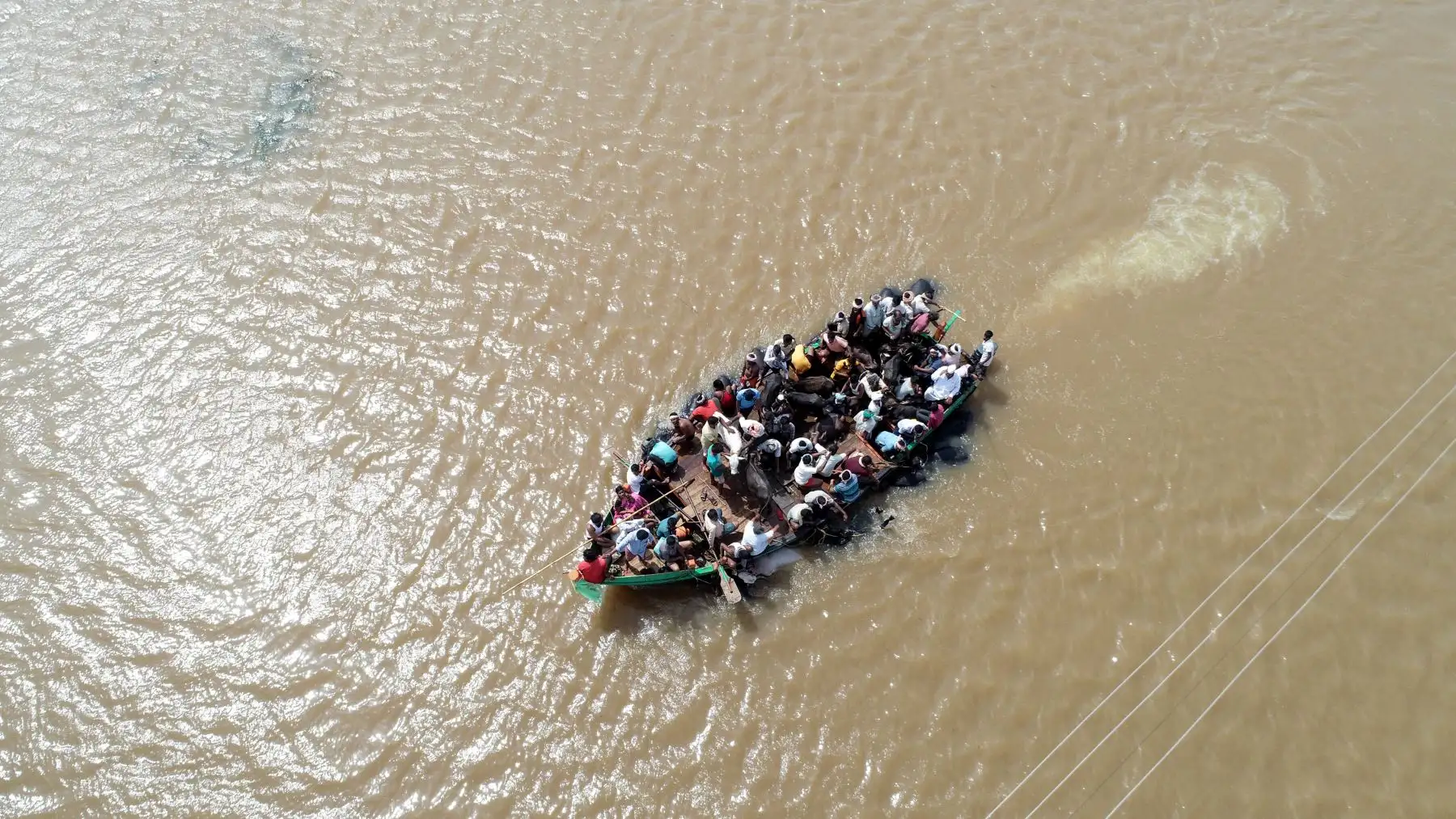 Vista aérea de rescatados en un barco por las inundaciones en la India. AFP