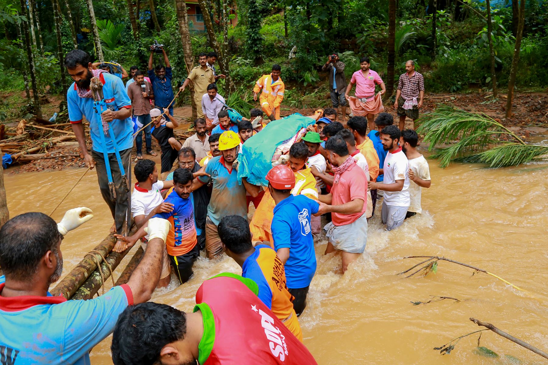 Los equipos de rescate llevan un cuerpo mientras cruzan un área inundada después de un deslizamiento de tierra en Kavalappara al sur de la India. AFP