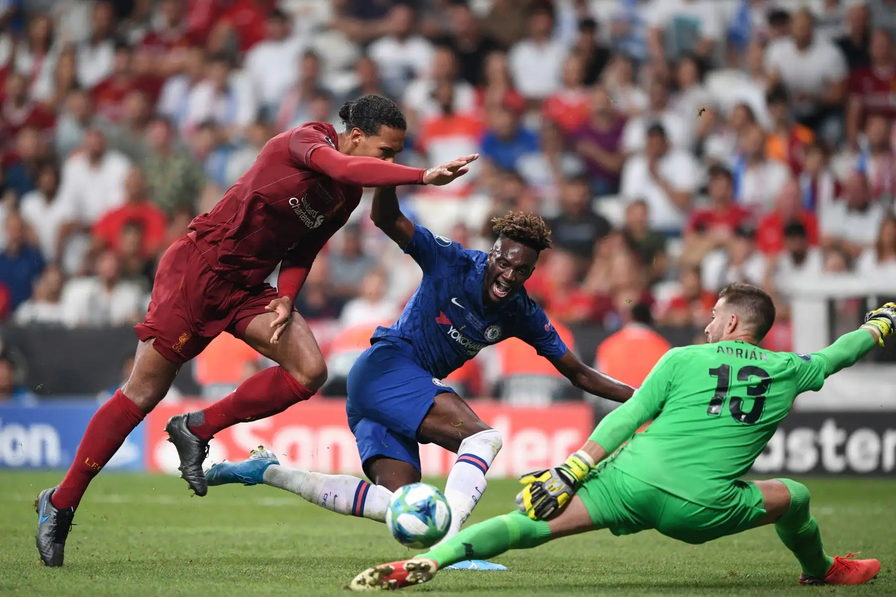 El delantero inglés del Chelsea, Tammy Abraham (C) compite por el balón con el defensor holandés del Liverpool Virgil van Dijk (L) y el portero español del Liverpool Adrian durante el partido de fútbol de la Supercopa de la UEFA 2019.Foto:AFP