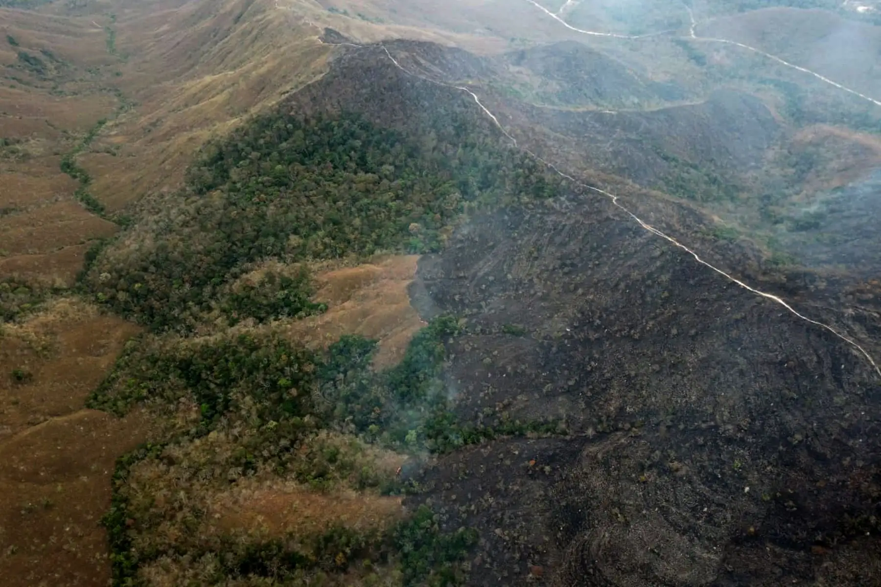 Fotografía aérea publicado por el Departamento de Bomberos de Mato Grosso que muestra áreas quemadas de tierra en las colinas del municipio de Chadapa dos Guimaraes en el estado de Mato Grosso, en el centro-oeste de Brasil, el 23 de agosto de 2019. AFP