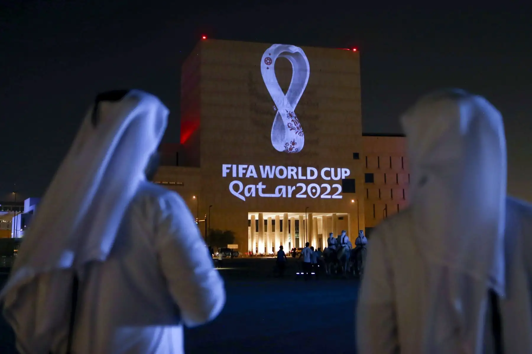 Los qataríes se reúnen en el mercado tradicional Souq Waqif de Doha, la capital, mientras el logotipo oficial de la Copa Mundial de la FIFA Qatar 2022 se proyecta en el frente de un edificio. Foto:AFP