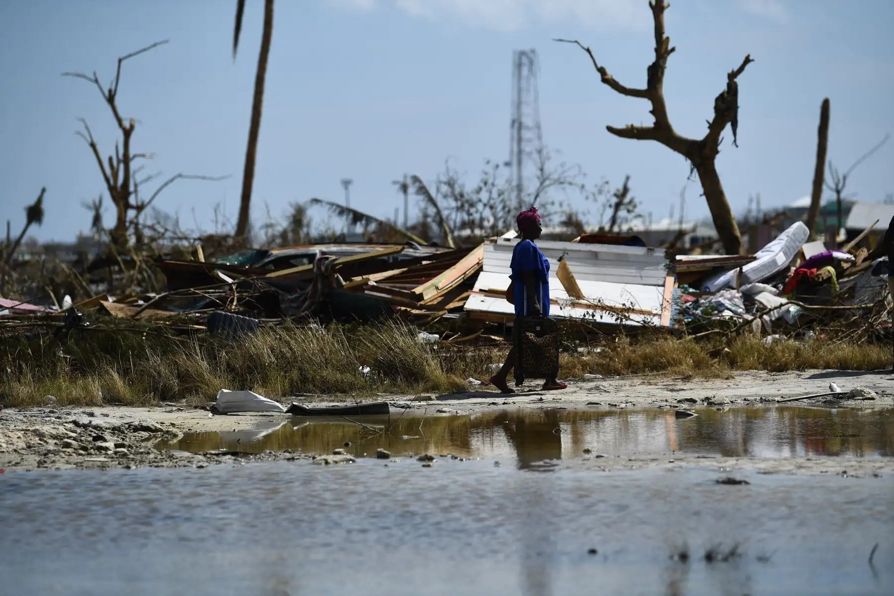 Una mujer lleva una bolsa junto al agua estancada en el barrio "Mudd" en Marsh Harbour, Gran Ábaco, tras el huracán Dorian. Los bahameños, los  perdieron todo en el paso devastador del huracán Dorian.
Brendan Smialowski / AFP