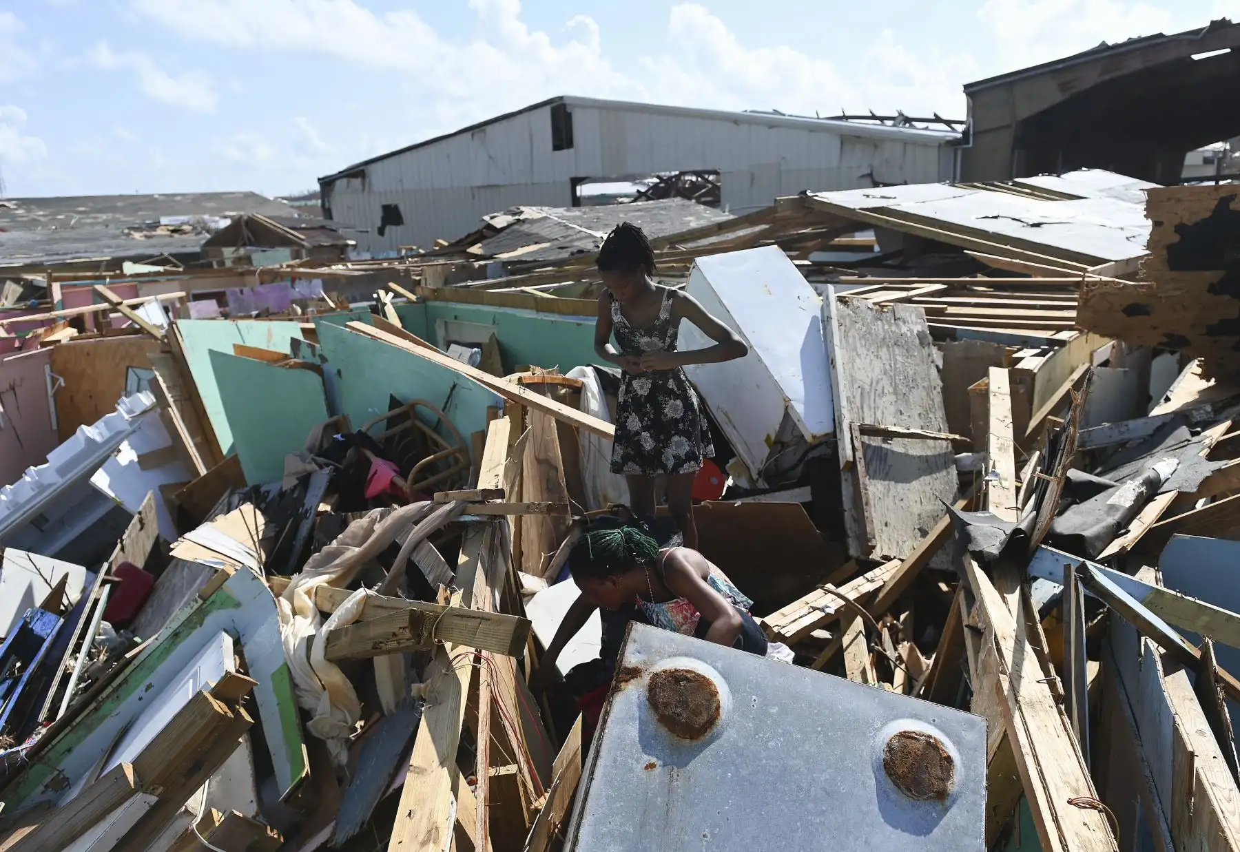 Margie Gerthadauphin (abajo) y su hija Kimberly observan su casa destruida mientras intenta salvar sus pertenencias en Marsh Harbour, Bahamas, una semana después del paso del huracán Dorian. Foto:AFP