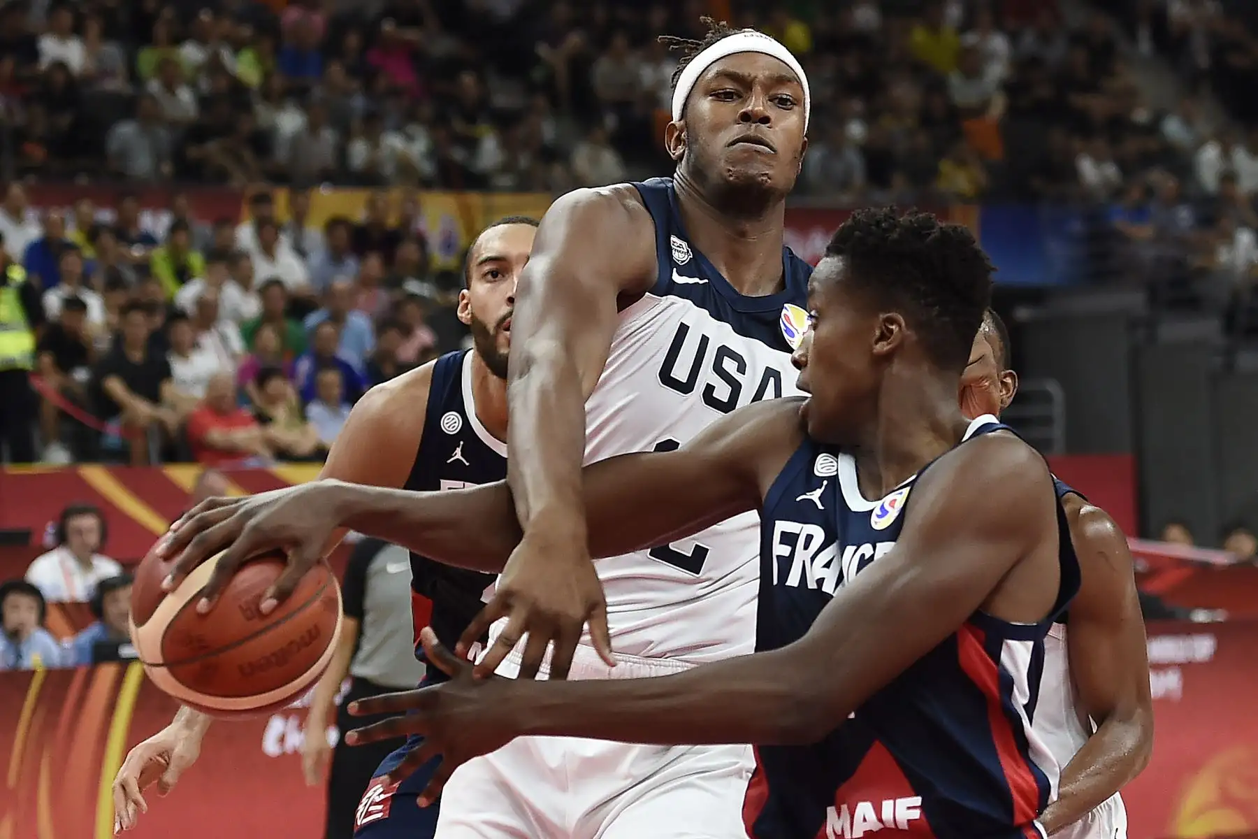 Myles Turner (C) de los Estados Unidos y Francia, Frank Ntilikina, luchan por el balón durante el partido de cuartos de final de la Copa Mundial de Baloncesto. Foto: AFP