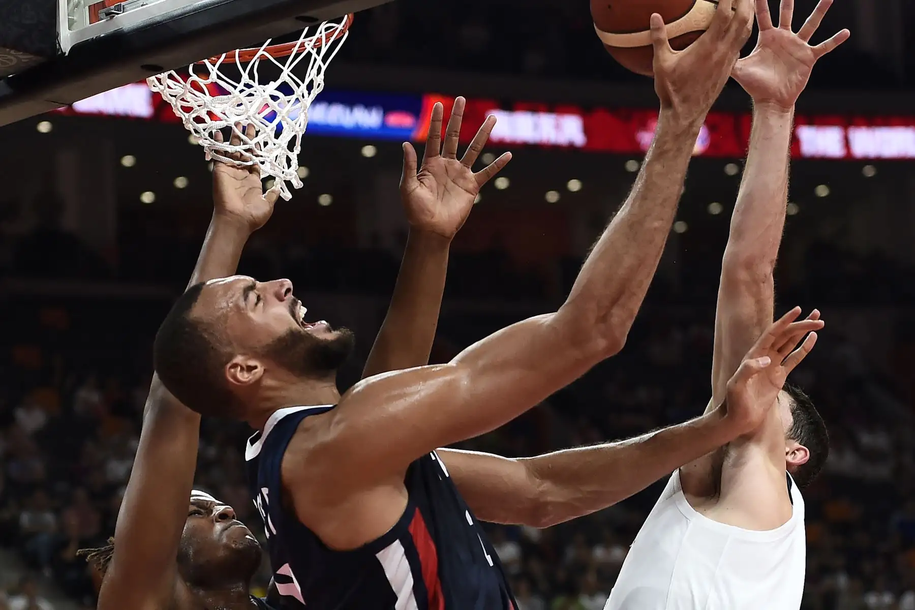 El francés Rudy Gobert (C) va a la canasta cuando Myles Turner de los EE. UU. Intenta bloquear durante el partido de cuartos de final de la Copa Mundial de Baloncesto. Foto: AFP