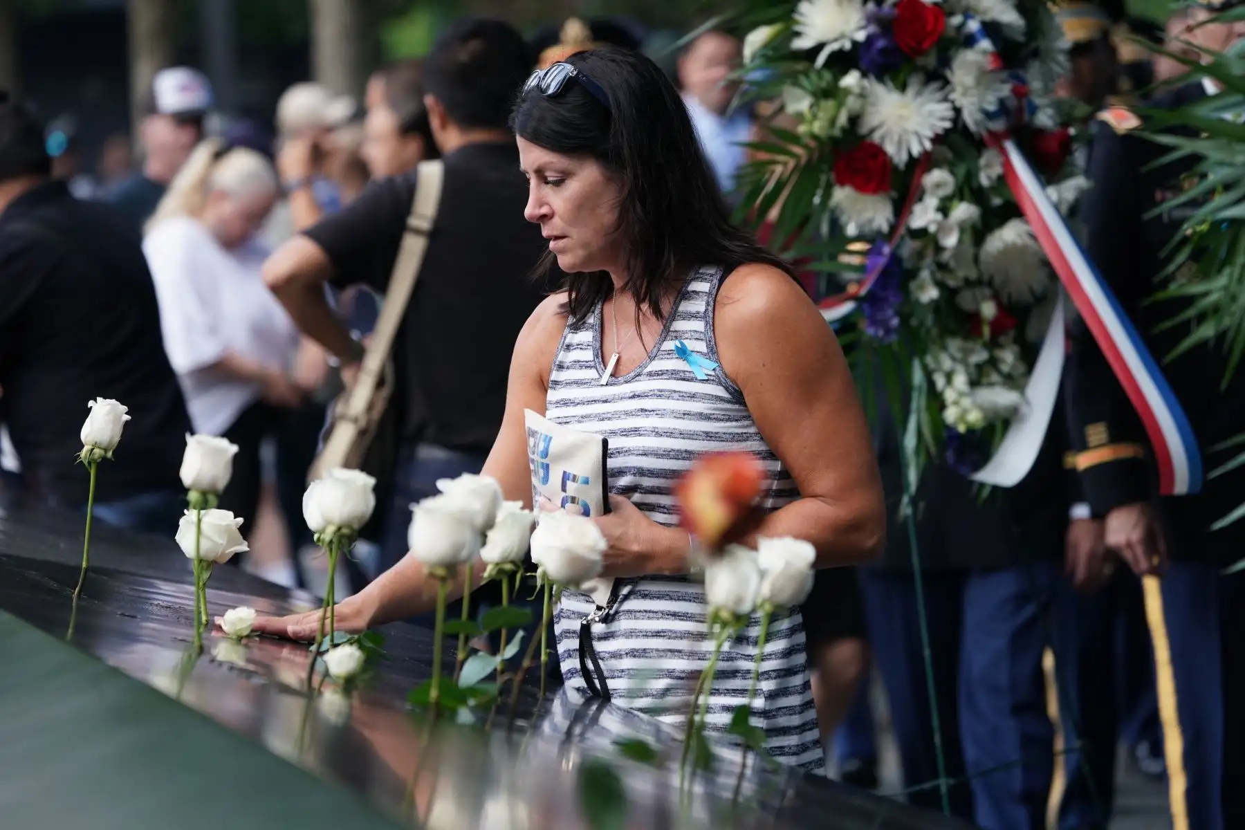 La gente deja flores durante la Ceremonia de Conmemoración del 11 de septiembre en el 9/11 Memorial en el World Trade Center  en Nueva York. Foto :AFP