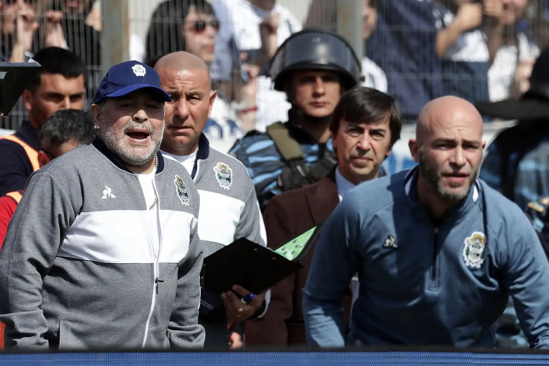 La ex estrella del fútbol argentino Diego Armando Maradona (L) y el nuevo entrenador del equipo de Gimnasia y Esgrima La Plata gestos durante su partido de fútbol de la Superliga de la Primera División de Argentina contra el Racing Club.
Foto:AFP
