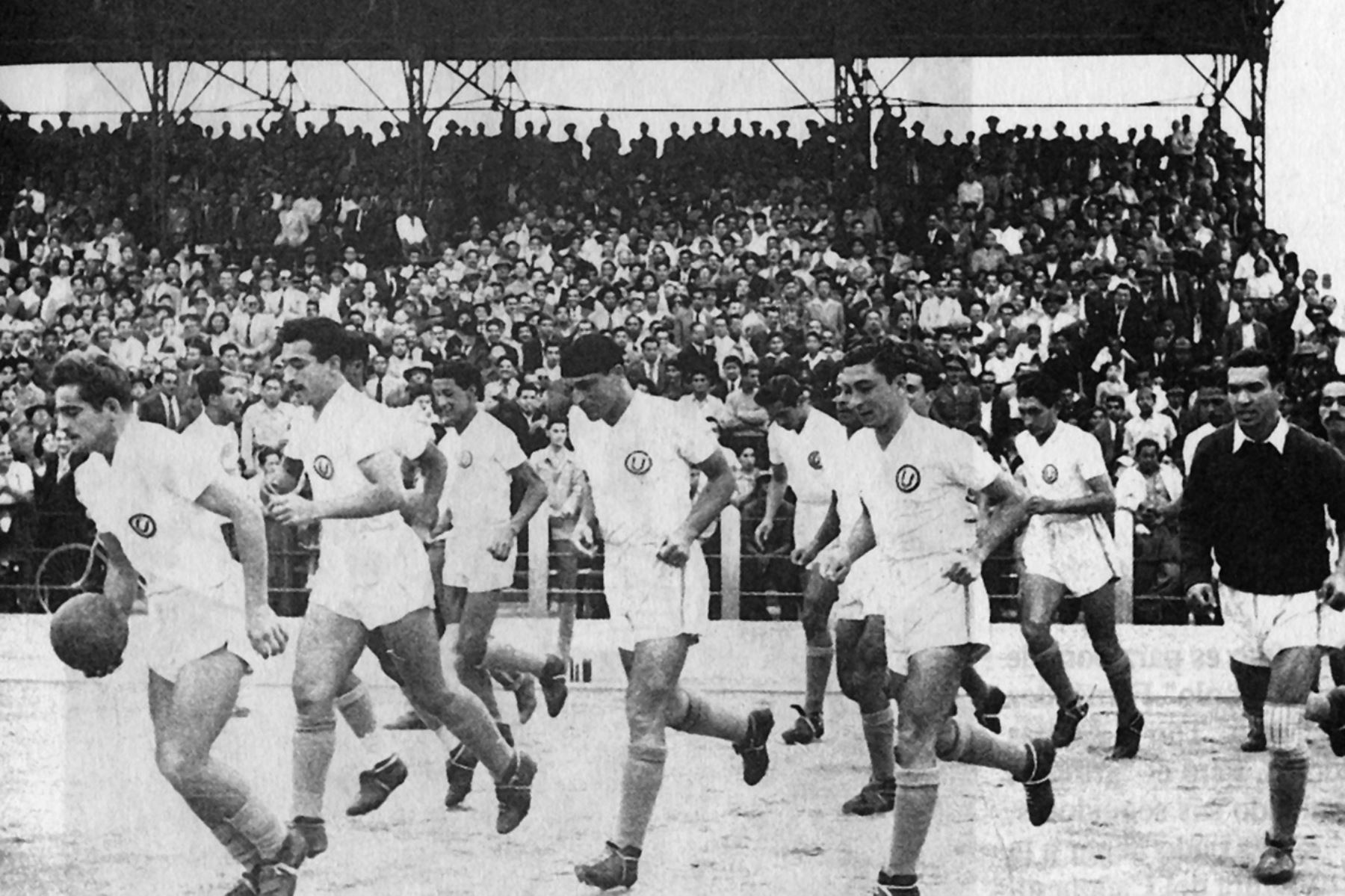 Equipo de Universitario de deportes saltando al campo de juego con  Teodoro "Lolo" Fernández a la cabeza, acompañado de Toto Terry.
Foto: Archivo el Peruano