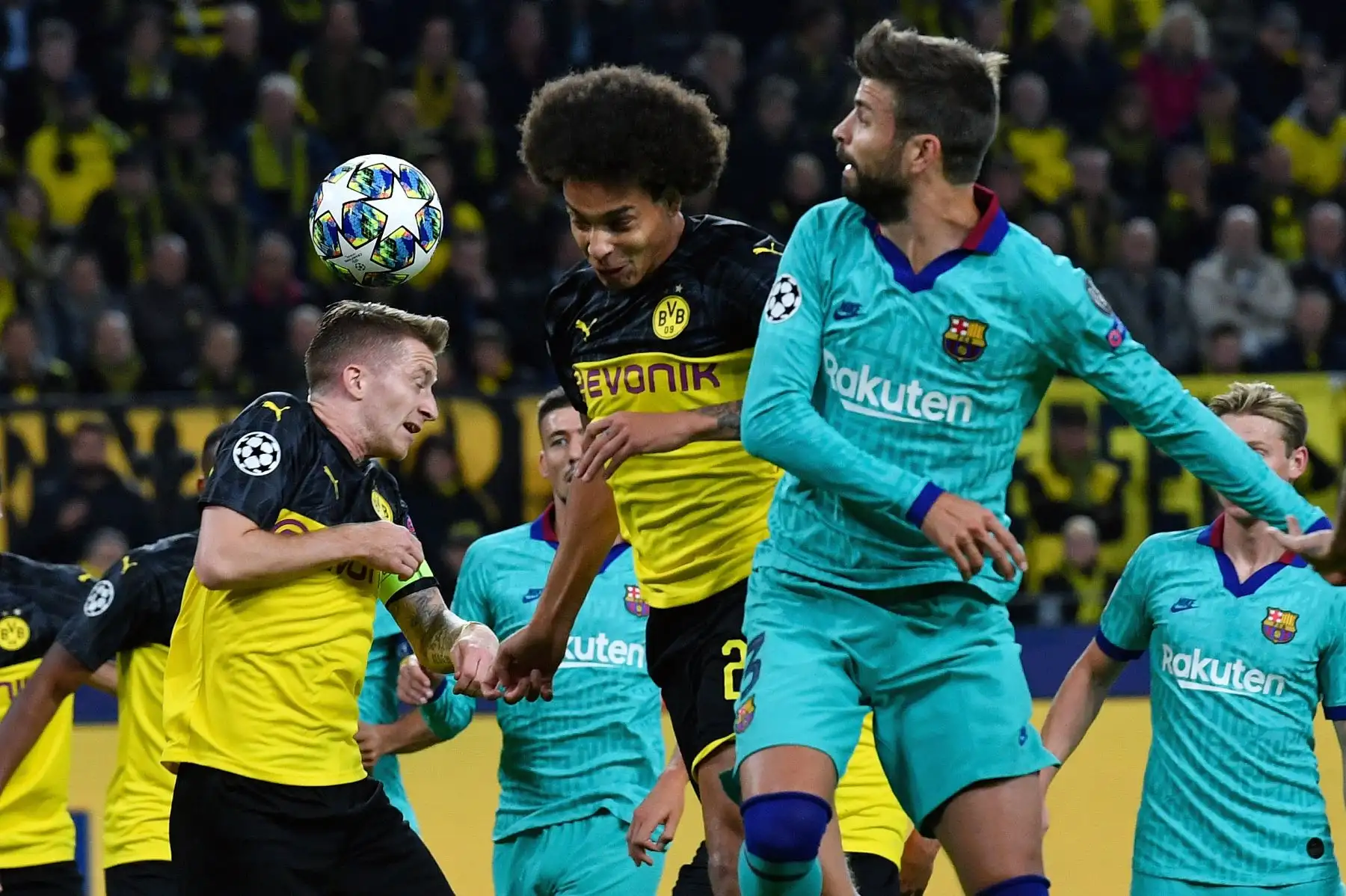 El alero alemán de Dortmund Marco Reus (L) y el mediocampista belga de Axel Witsel compiten por el balón con el defensa del Barcelona Gerard Piqué durante el partido de fútbol del Grupo F de la Liga de Campeones de la UEFA.Foto:AFP