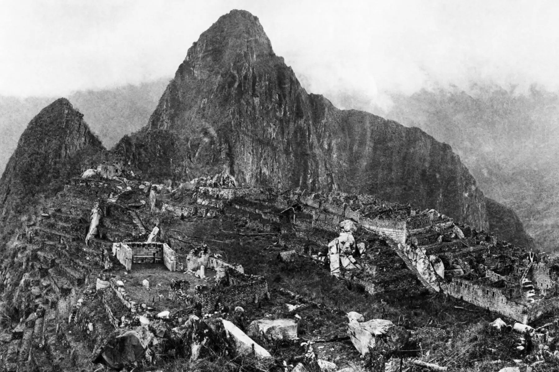 Machu Picchu en vista panóramica, resalta  la Plaza Sagrada, con el Templo Principal y el templo de tres ventanas a la derecha. Por encima de estos y conectado con ellos por la mejor escalera en Machu Picchu se encuentra la colina sagrada, en la que se encuentra el Intihuatana, o piedra de reloj solar.
Foto:  Hiram Bingham / National Geographic