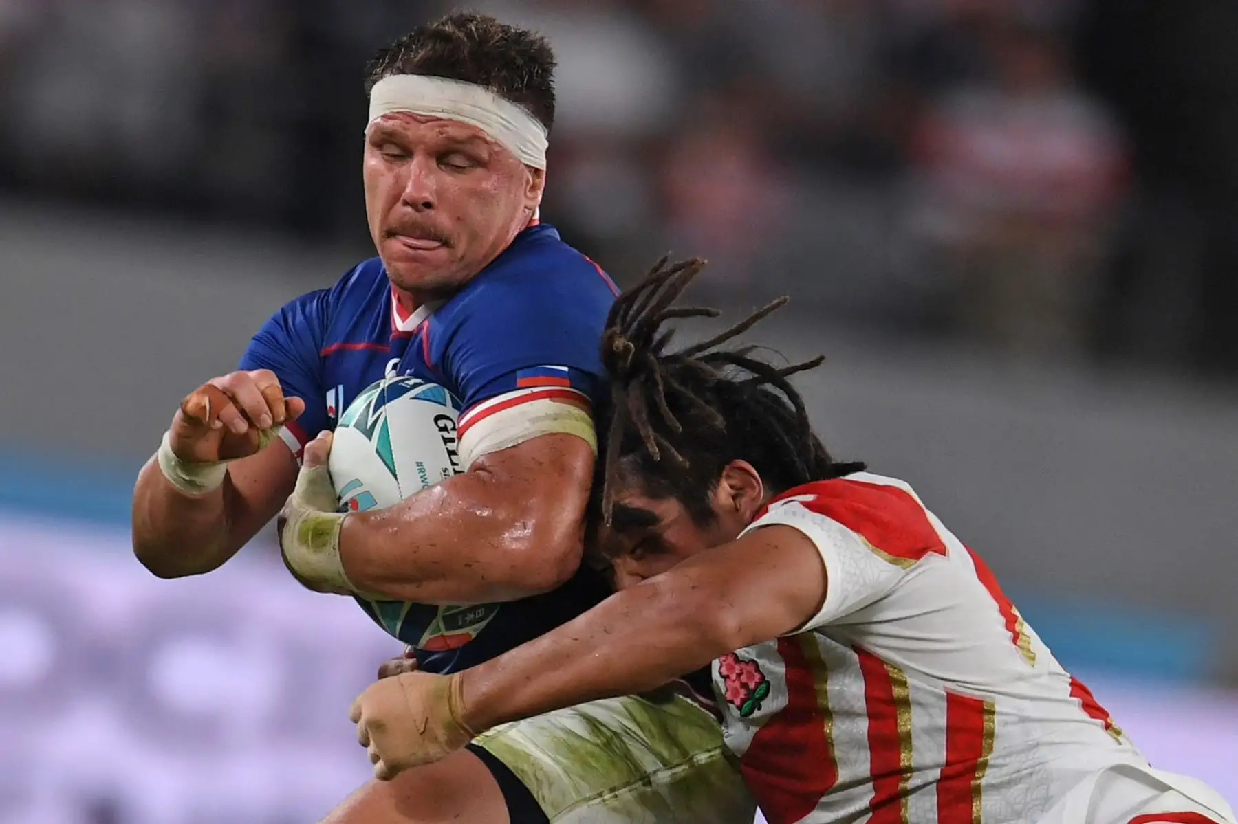 El centro de Rusia, Dmitry Gerasimov, es abordado por el japones Shota Horie durante el partido del Grupo A de la Copa Mundial de Rugby de Japón 2019. Foto: AFP