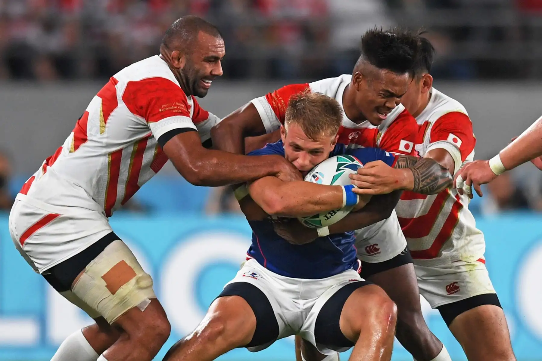 El ala rusa Kirill Golosnitskiy (C) es abordado por los jugadores japoneses durante el partido de la Copa Mundial de Rugby entre Japón y Rusia en Tokio. Foto: AFP