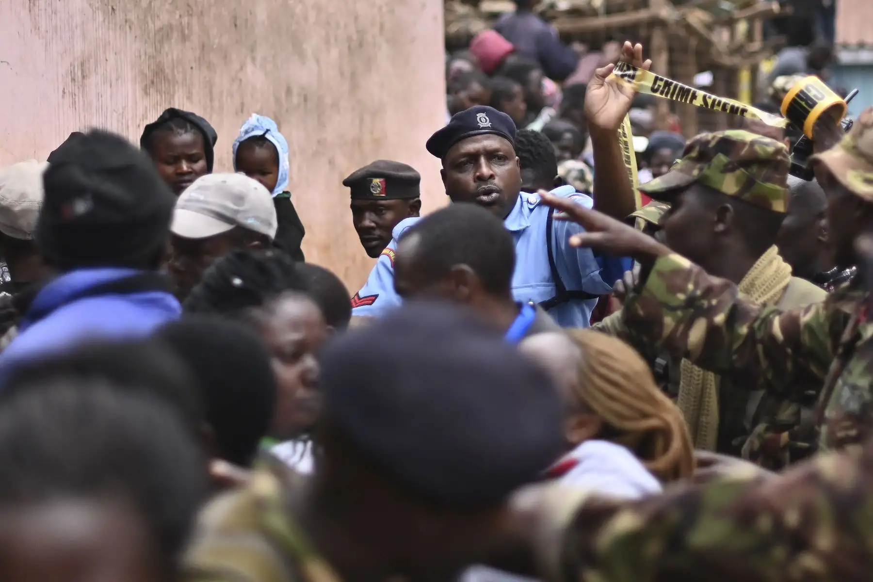 Los oficiales de policía empujan a una multitud de espectadores mientras aseguran la escena donde un bloque de aulas se derrumbó en la escuela primaria Precious Talents en el distrito electoral Dagoretti de Nairobi.
Foto: AFP