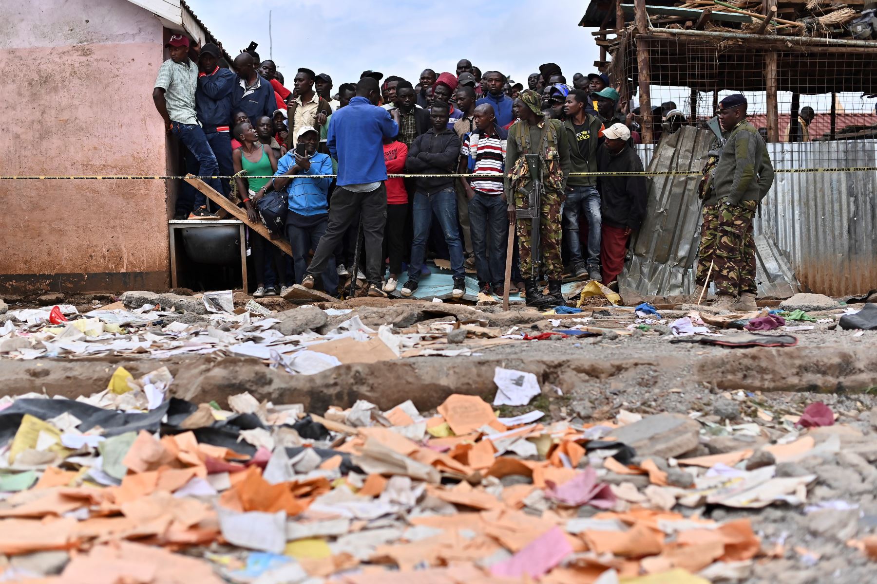 Los familiares esperan afuera de un perímetro de seguridad establecido cerca del área de un edificio escolar derrumbado, en Nairobi. Siete niños murieron y decenas resultaron heridos cuando un edificio escolar se derrumbó en la capital de Kenia.
Foto: AFP