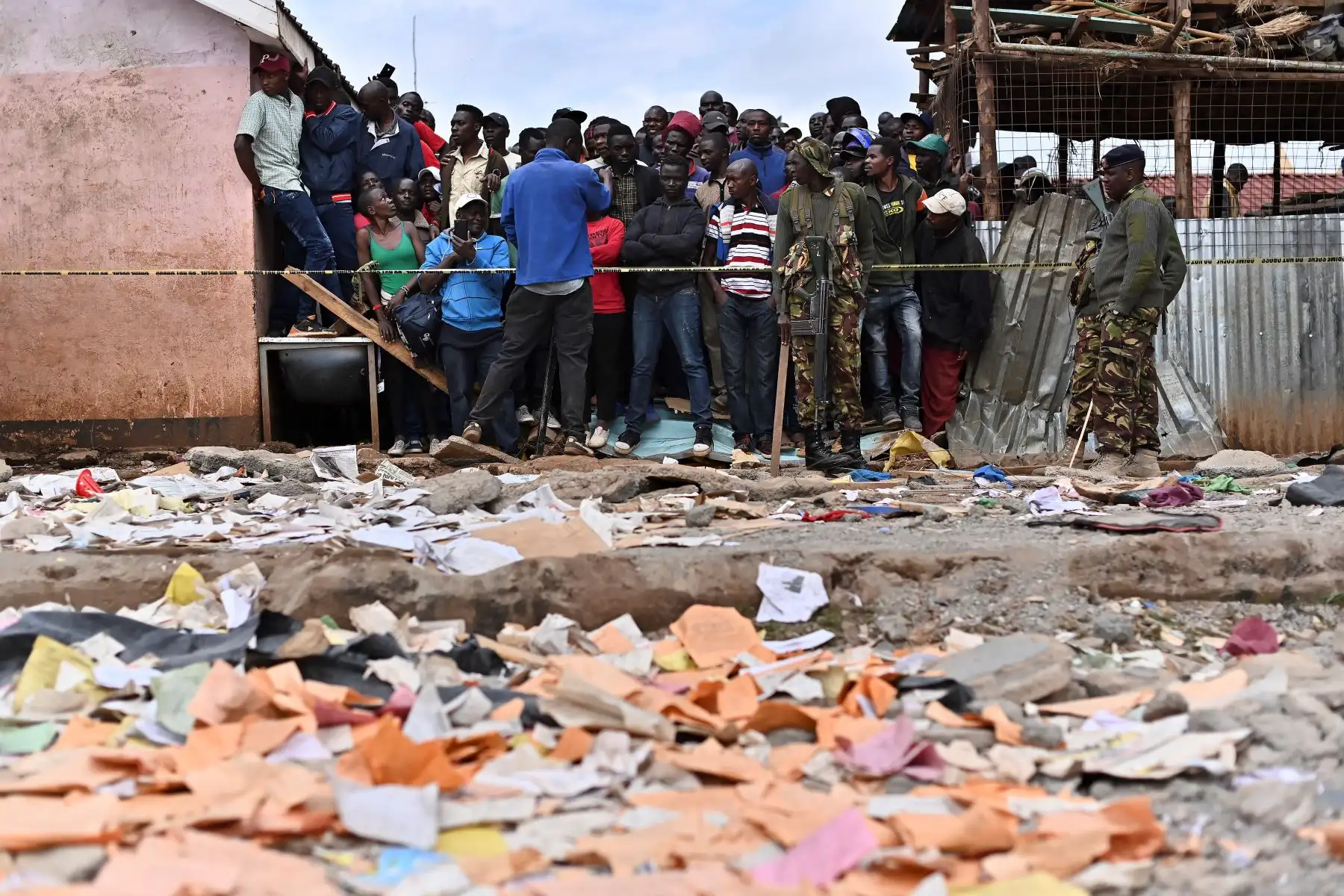 Los familiares esperan afuera de un perímetro de seguridad establecido cerca del área de un edificio escolar derrumbado, en Nairobi. Siete niños murieron y decenas resultaron heridos cuando un edificio escolar se derrumbó en la capital de Kenia.
Foto: AFP