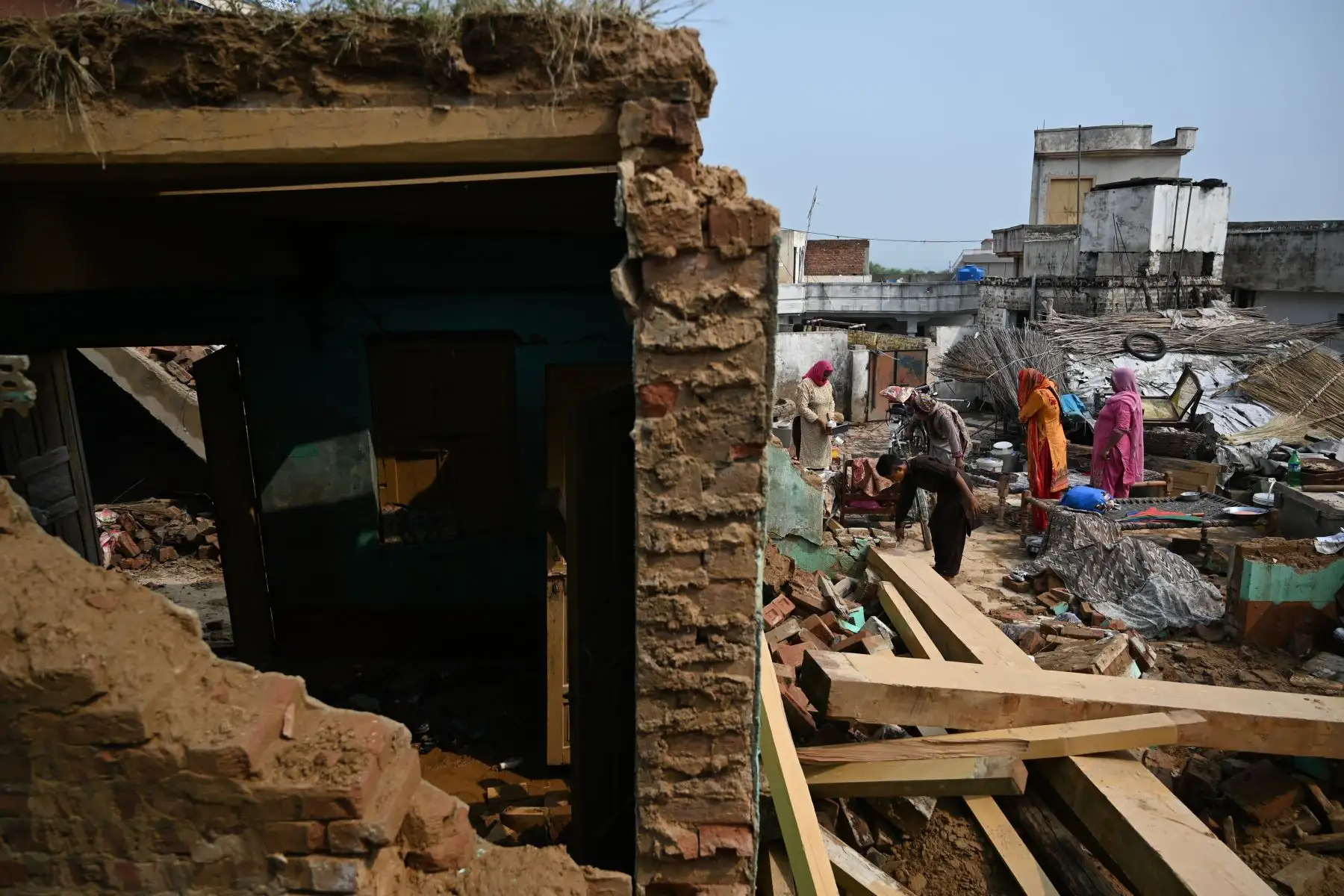Residentes paquistaníes miran una casa derrumbada en un área afectada por un terremoto en las afueras de Mirpur en Pakistán. Foto: AFP