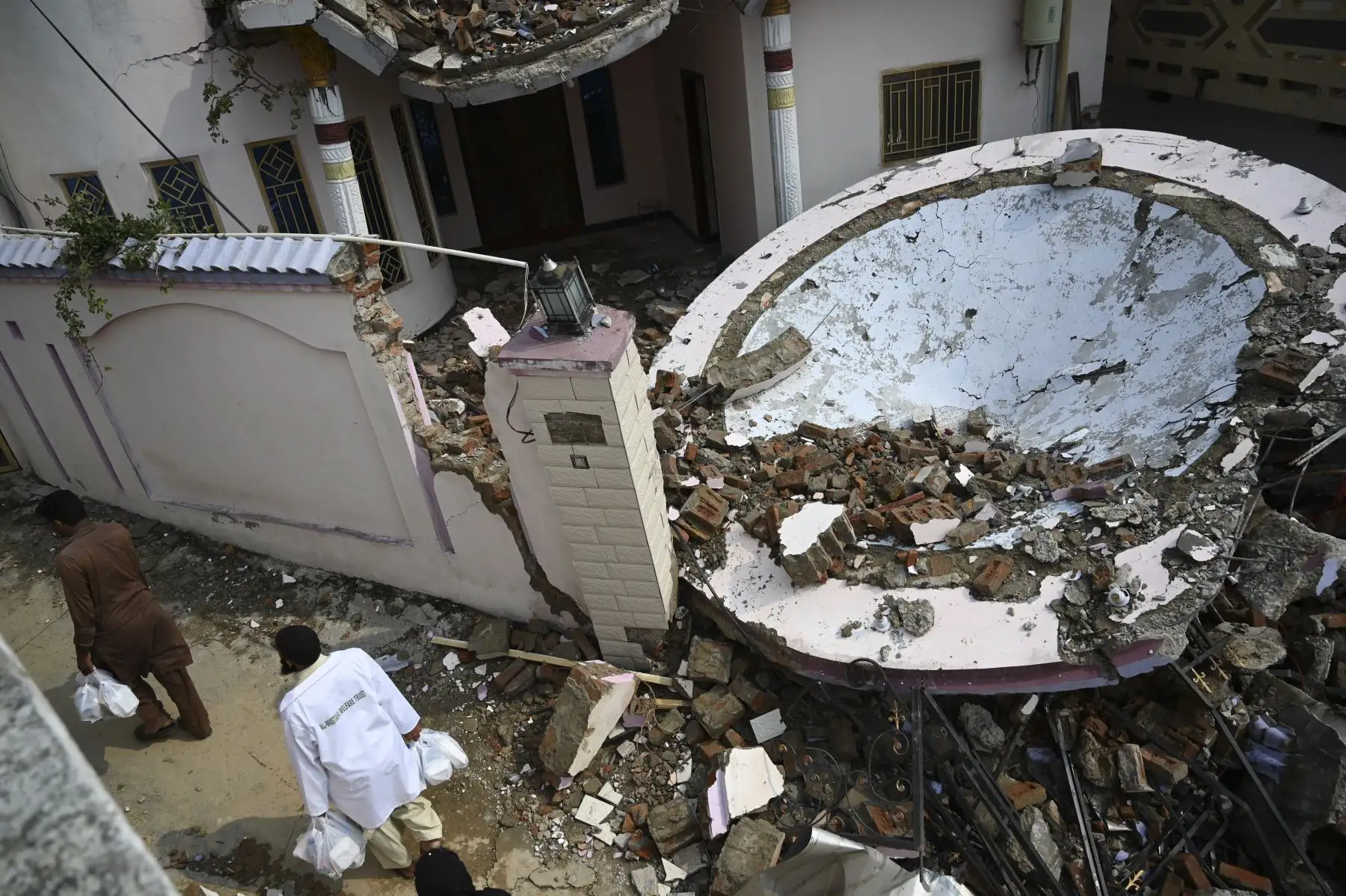 Un sobreviviente del terremoto mueve sus pertenencias entre los escombros de las casas derrumbadas en las afueras de Mirpur en Pakistán. Foto: AFP