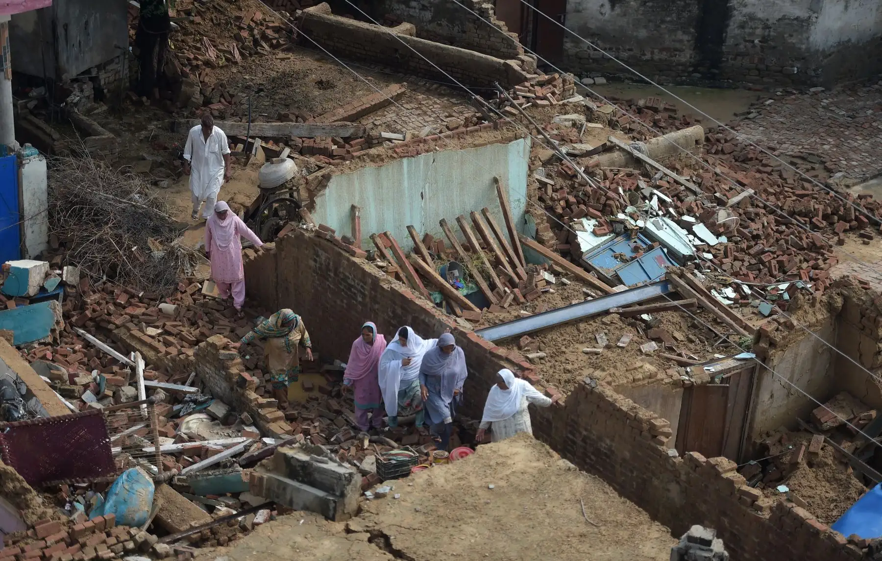 Un sobreviviente del terremoto mueve sus pertenencias entre los escombros de las casas derrumbadas en las afueras de Mirpur en Pakistán. Foto: AFP