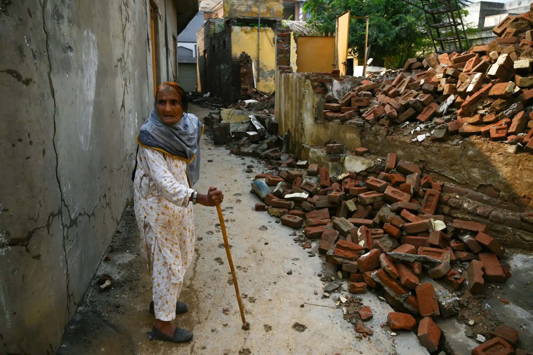 Una anciana camina entre los escombros de una casa derrumbada en Mirpur,  Pakistán. Foto: AFP