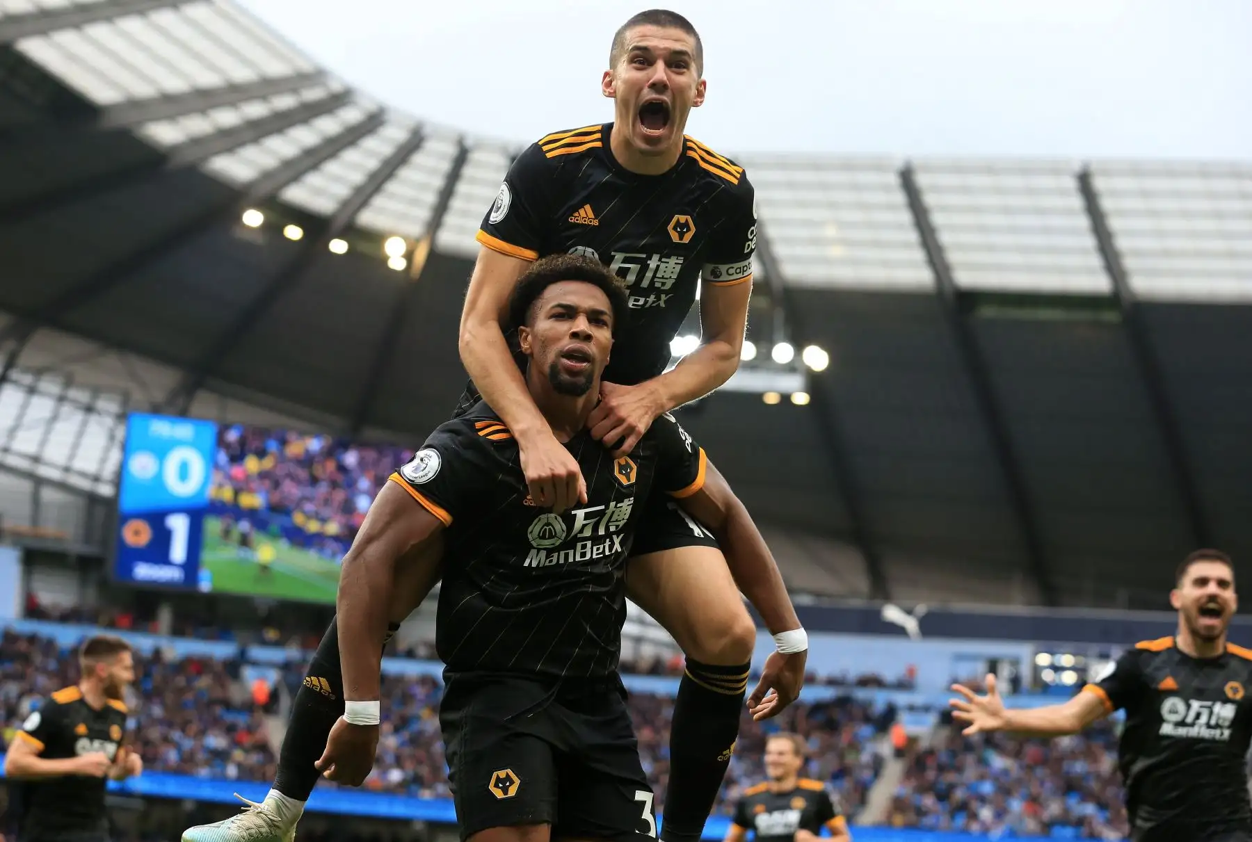 El delantero español de Wolverhampton, Adama Traore, celebra el gol de apertura junto al defensor inglés Conor Coady, en partido disputado contra el Manchester City por Premier League. Foto: AFP