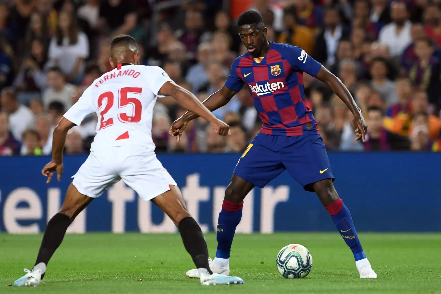 El delantero Ousmane Dembele del Barcelona trata de driblar al centro campista Fernando Reges del Sevilla por Liga Santander. Foto: AFP