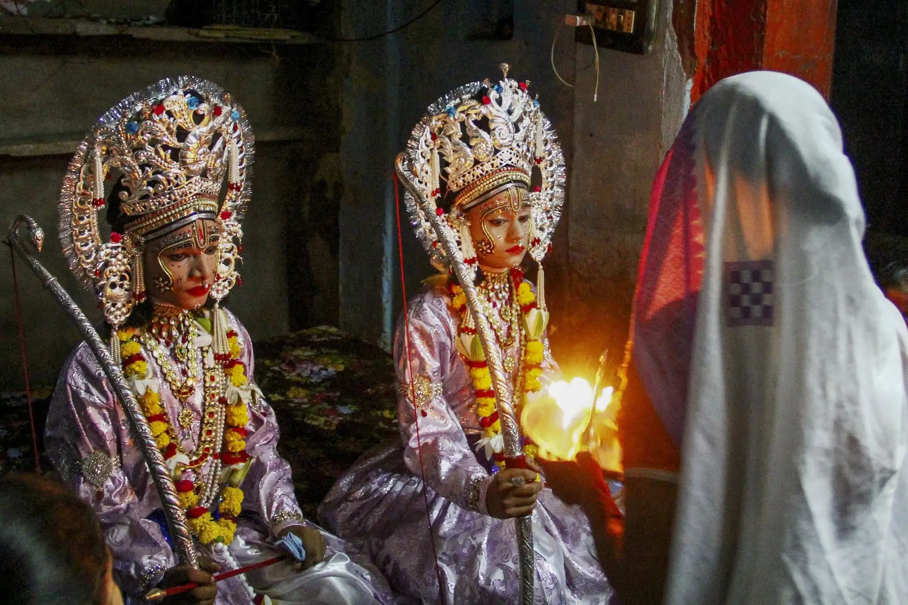 Artistas vestidos como el dios hindú Rama (L) y su compañero Laxman se sientan dentro de un templo antes de una procesión religiosa en la India. Foto: AFP