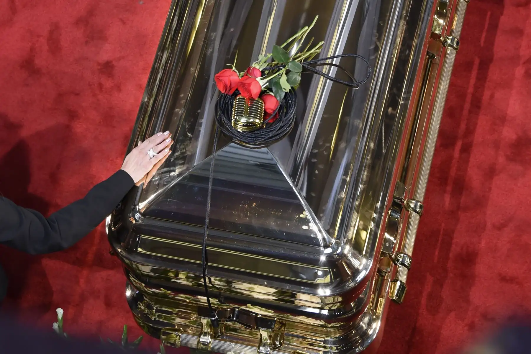 Un micro y rosas se ven en la parte superior del ataúd de la leyenda del canto mexicano fallecido, José José, durante un homenaje en el Palacio de Bellas Artes de la Ciudad de México. Foto: AFP