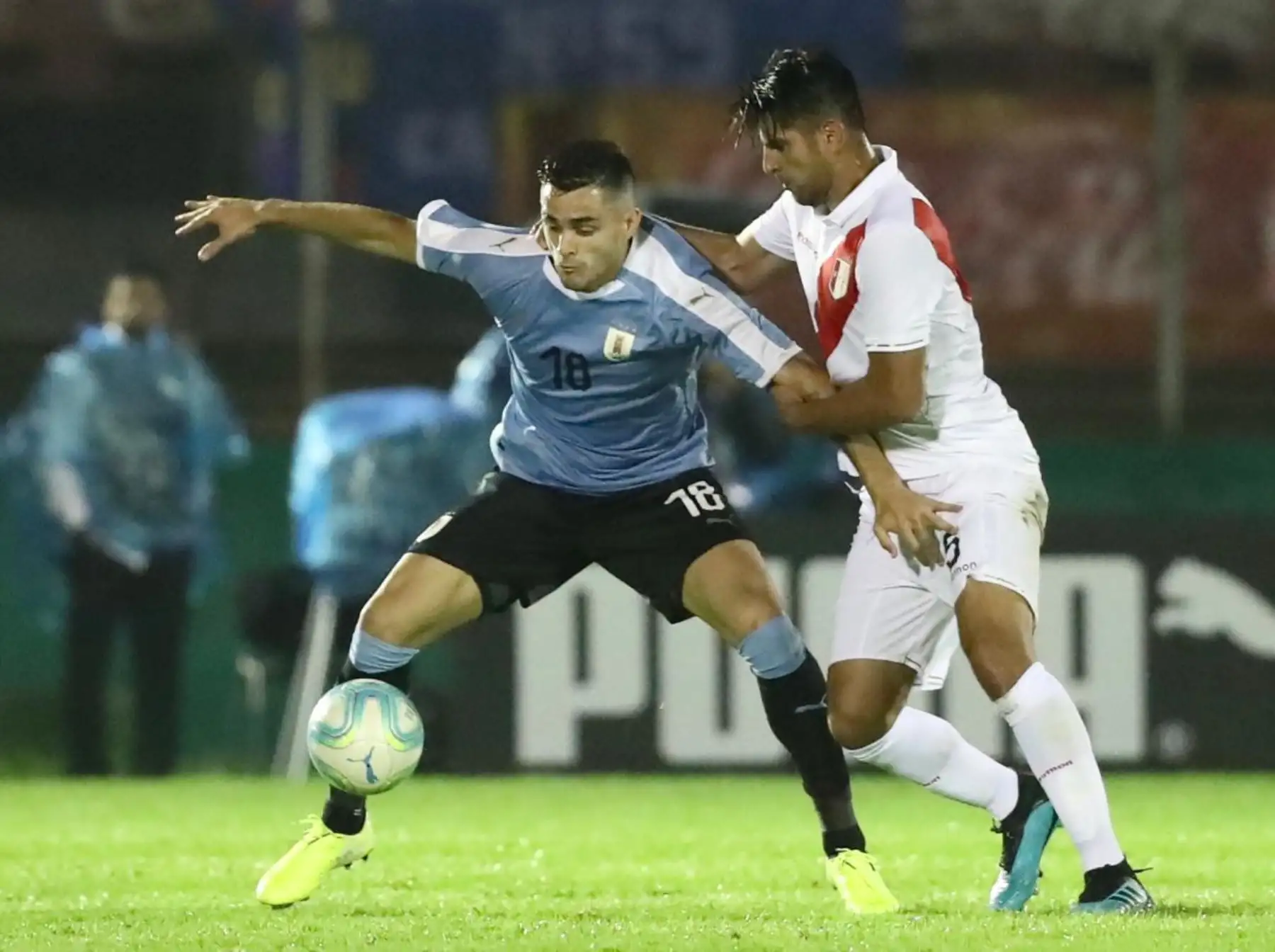Maxi Gomez de Uruguay intenta proteger el balón ante marca del defensor peruano Carlos Zambrano. Foto: FPF