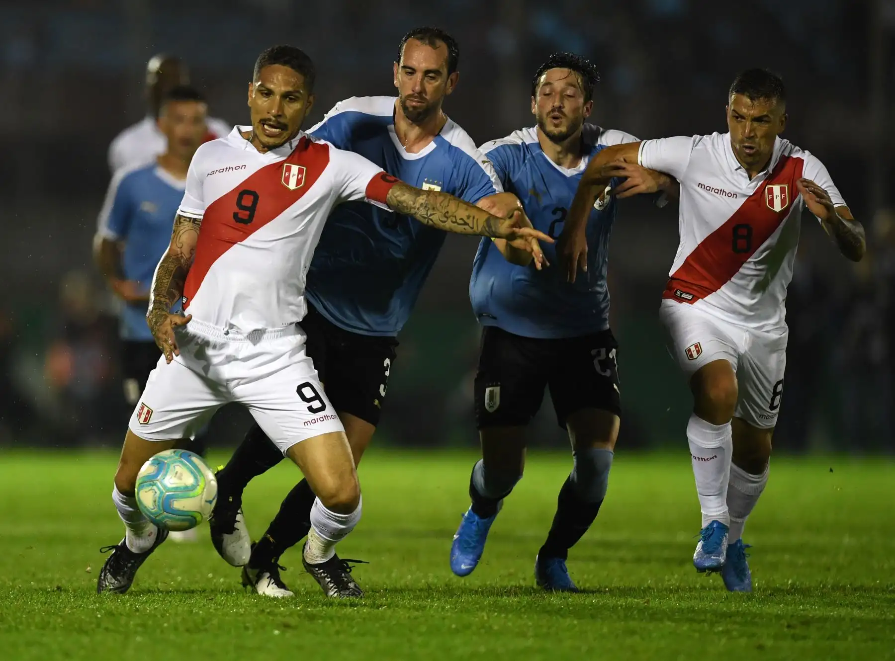 El delantero peruano Paolo Guerrero controla el balón ante la presión del uruguayo Diego Godin. Foto: AFP