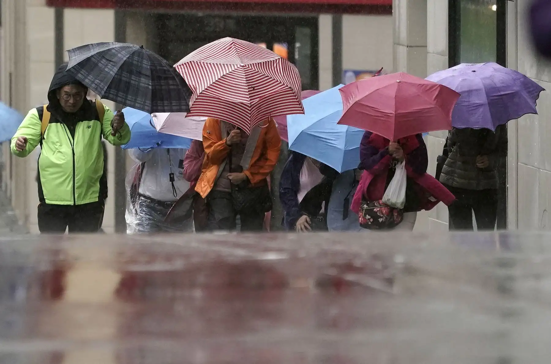 Peatones luchan contra las fuertes lluvias y viento en Tokio. Foto: EFE