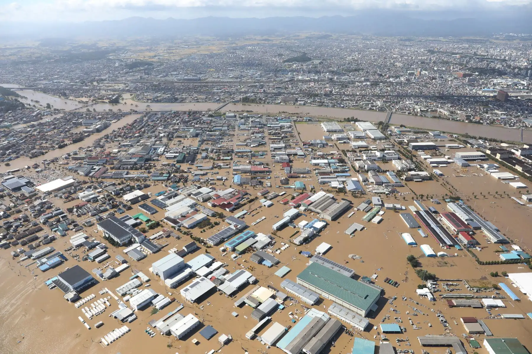Vista aérea muestra casas inundadas junto a la orilla  del río Chikuma en Nagano, un día después de que el tifón Hagibis barriera el centro y este de Japón. Foto: AFP