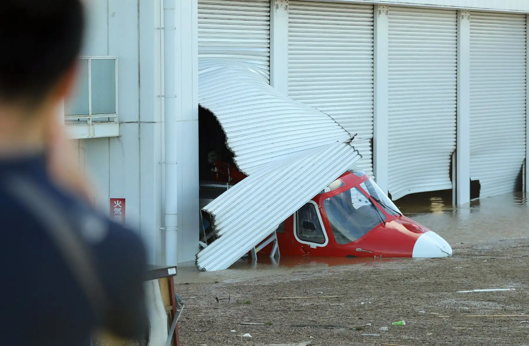 Un residente mira un helicóptero en una zona inundada en Kawagoe, prefectura de Saitama, un día después de que el tifón Hagibis se extendiera por el centro y el este de Japón. Foto: AFP