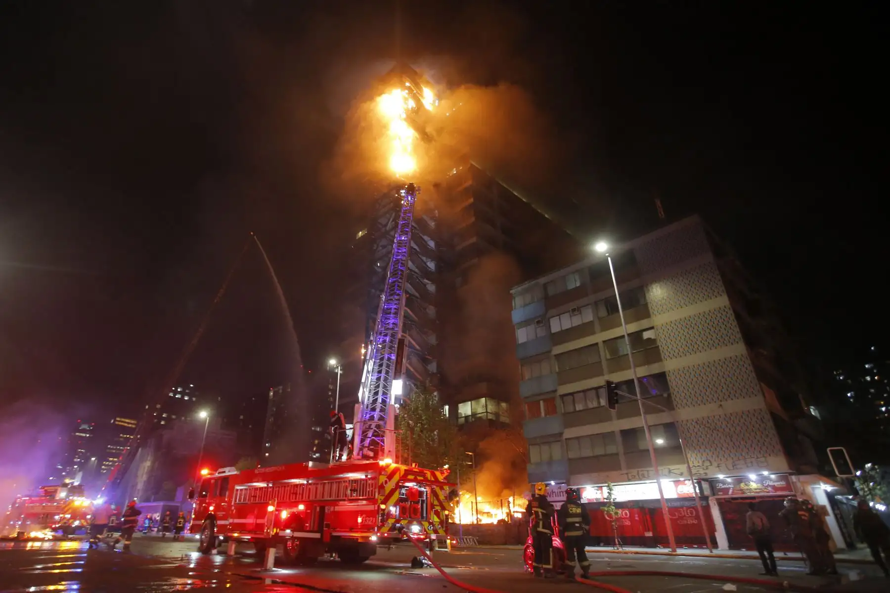 Las llamas envuelven el emblemático edificio en el  centro de Santiago luego de una protesta masiva de evasión de tarifas.  Foto: AFP