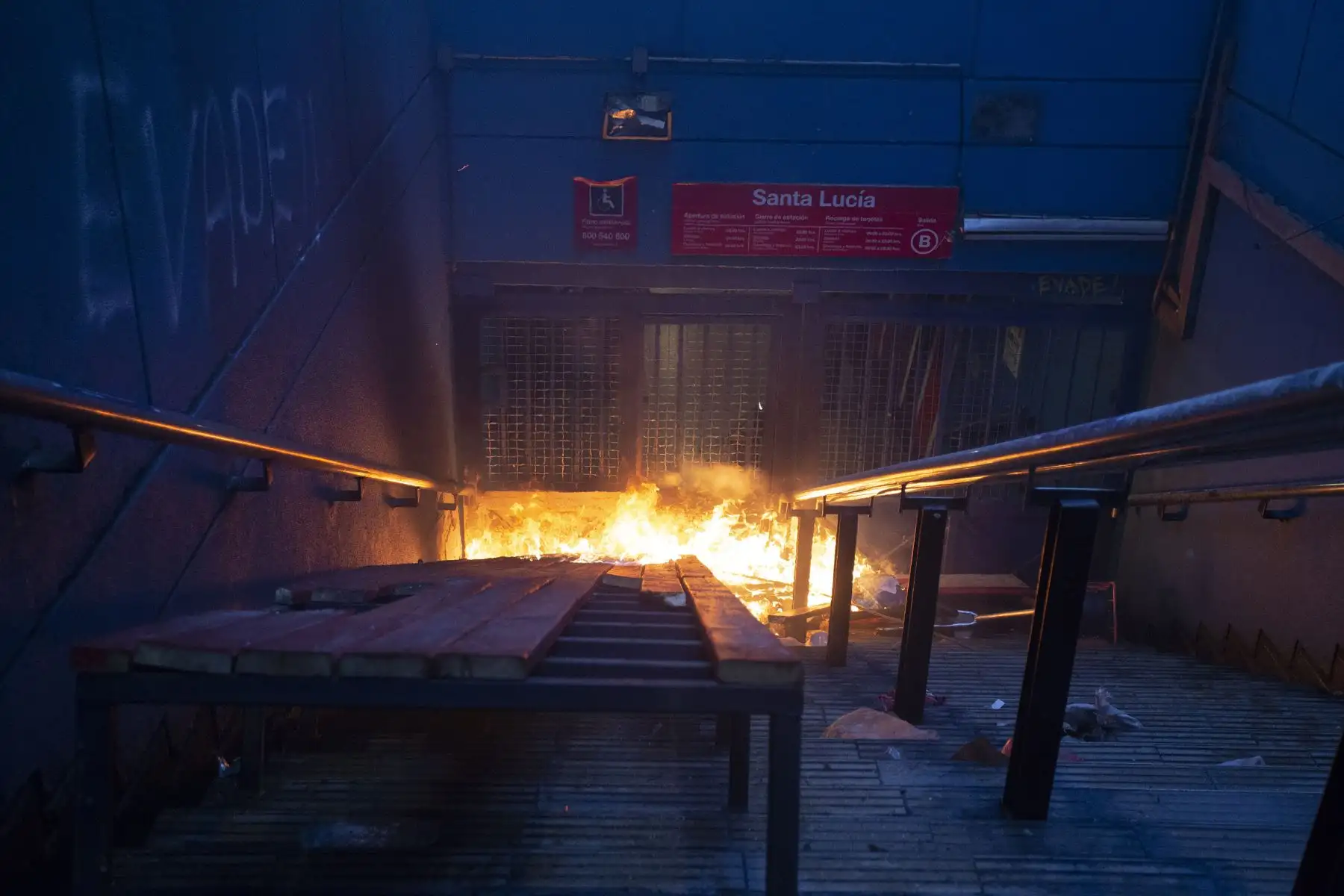 Un incendio provocado por los manifestantes arde en una entrada a la estación de metro de Santa Lucía en Santiago. AFP