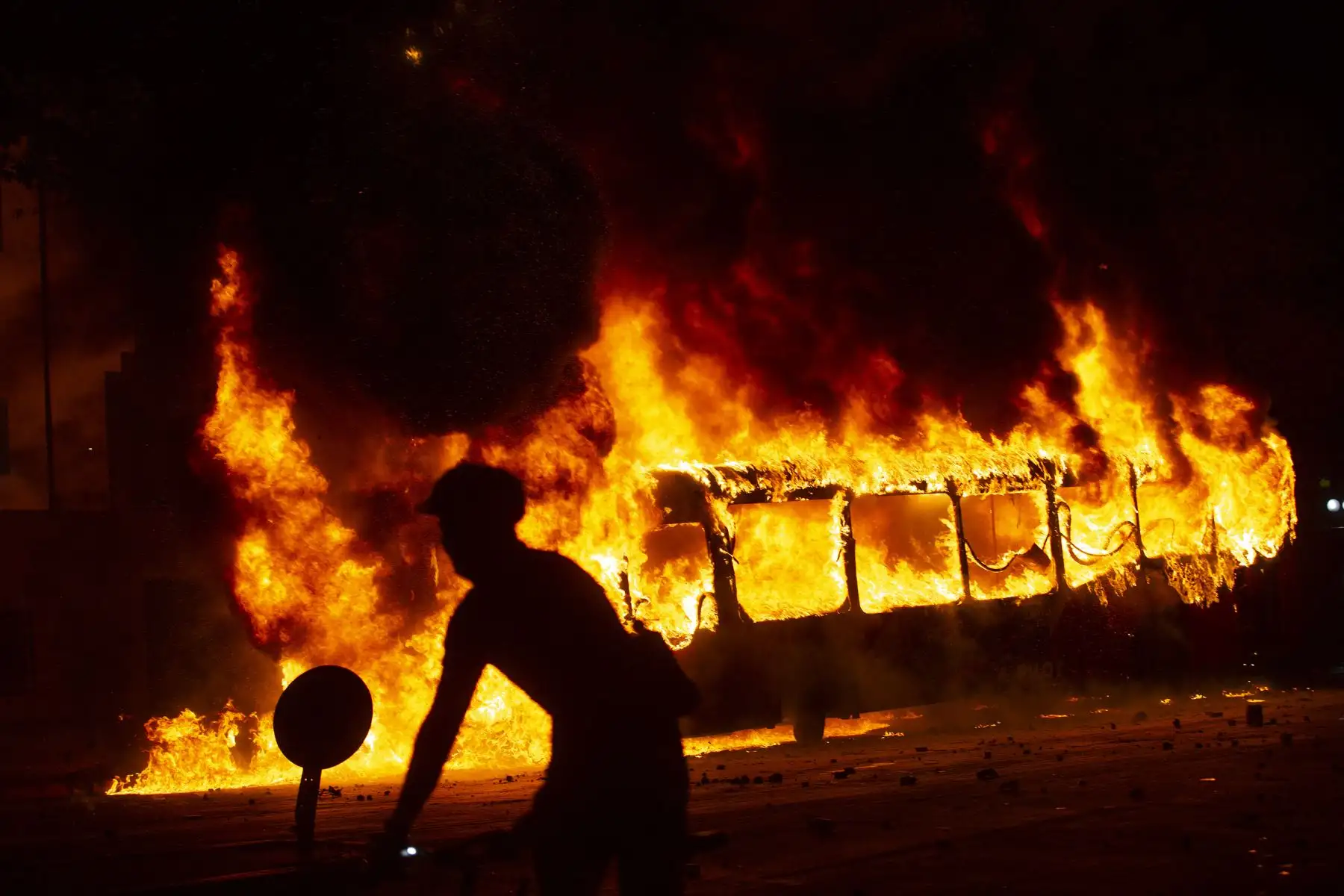 Un autobús se incendia en el centro de Santiago,  luego de una protesta masiva de evasión de tarifas. Estudiantes de escuelas y universidades se unieron a una protesta masiva de evasión de tarifas en el metro de Santiago después del aumento más alto de tarifas en los últimos años, paralizando dos de sus líneas principales. AFP