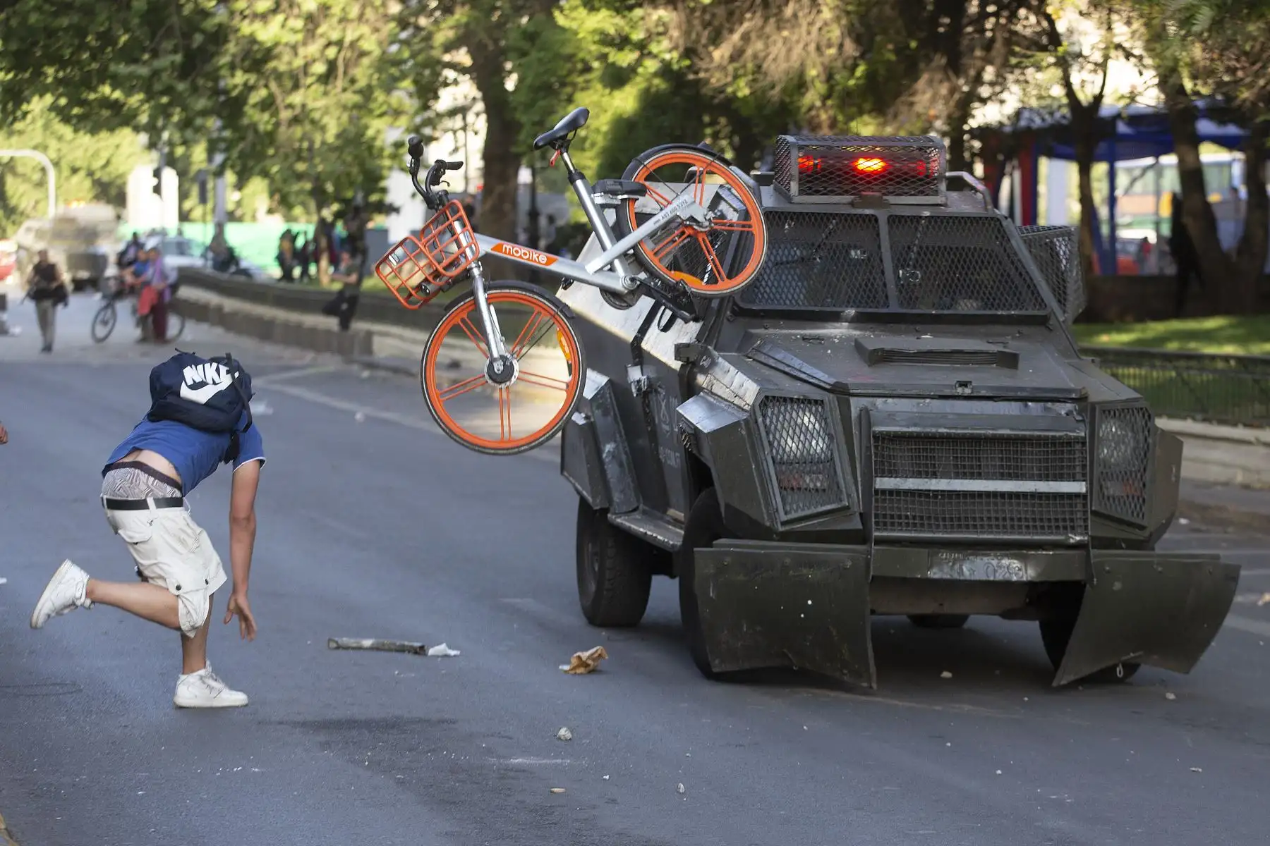 Los manifestantes se enfrentan con la policía antidisturbios después de una protesta masiva de evasión de tarifas en el centro de Santiago. AFP