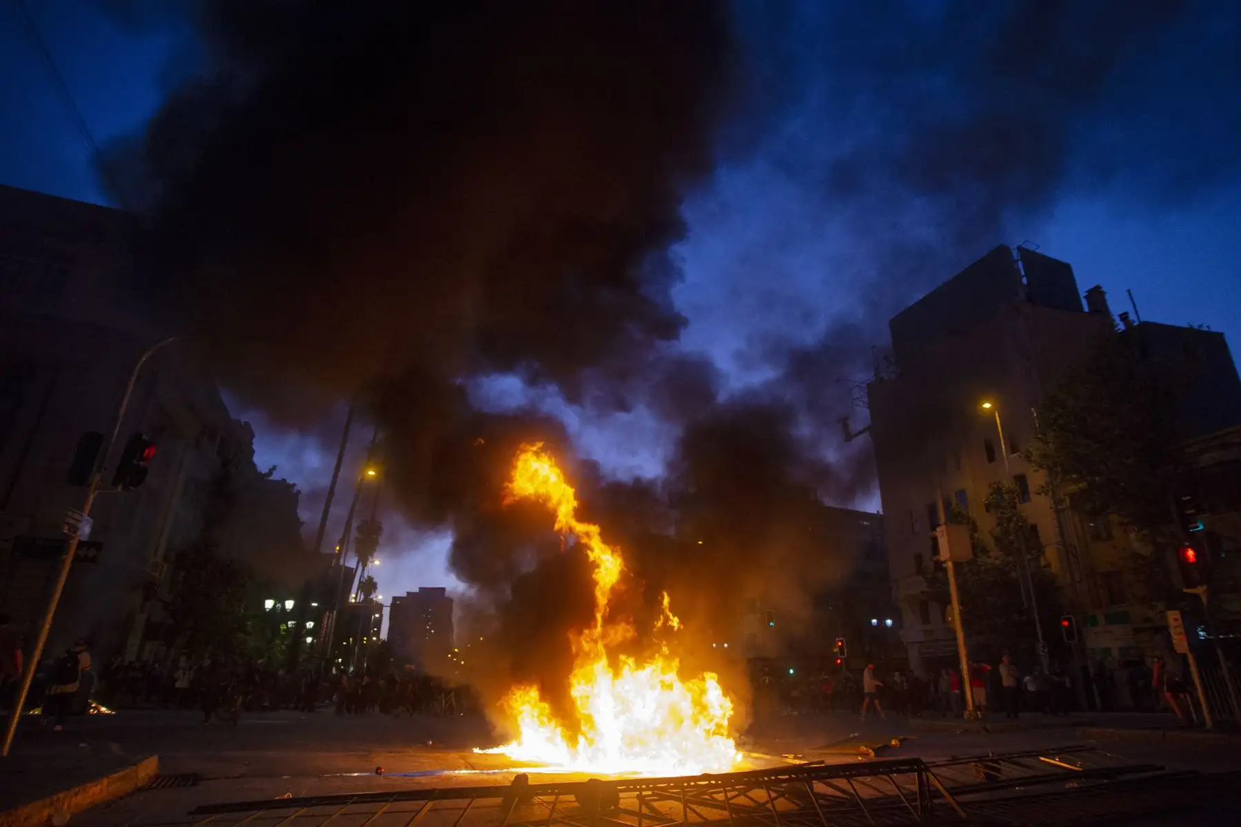 Una barricada arde en el centro de Santiago,  luego de una protesta masiva de evasión de tarifas. AFP