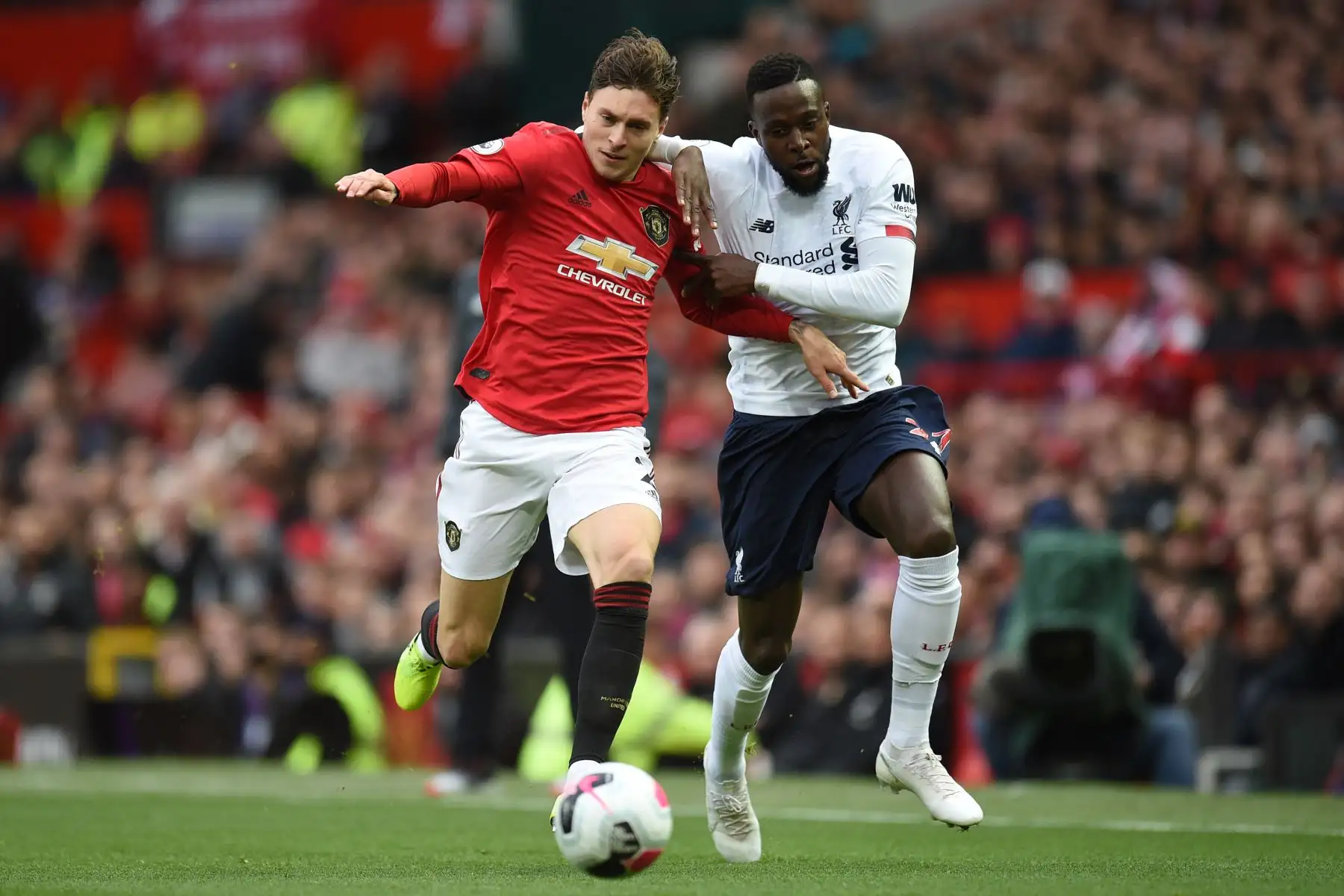 El defensor sueco del Manchester United, Victor Lindelof, compite con el delantero belga del Liverpool, Divock Origi, en partido por Premier League. Foto: AFP