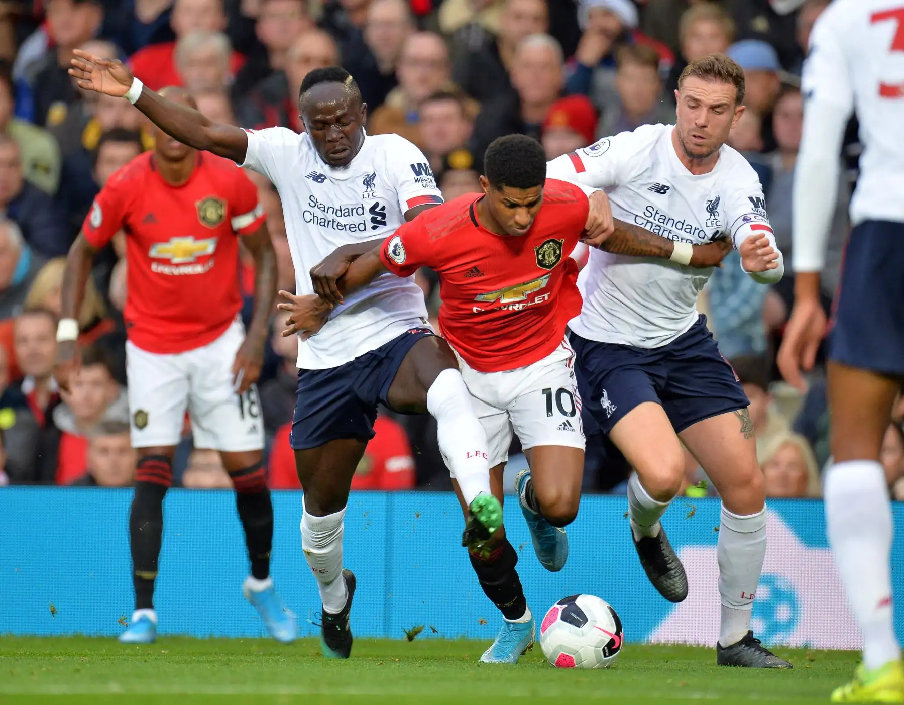Marcus Rashford del Machester United evita fuerte marca del Liverpool. Foto: EFE