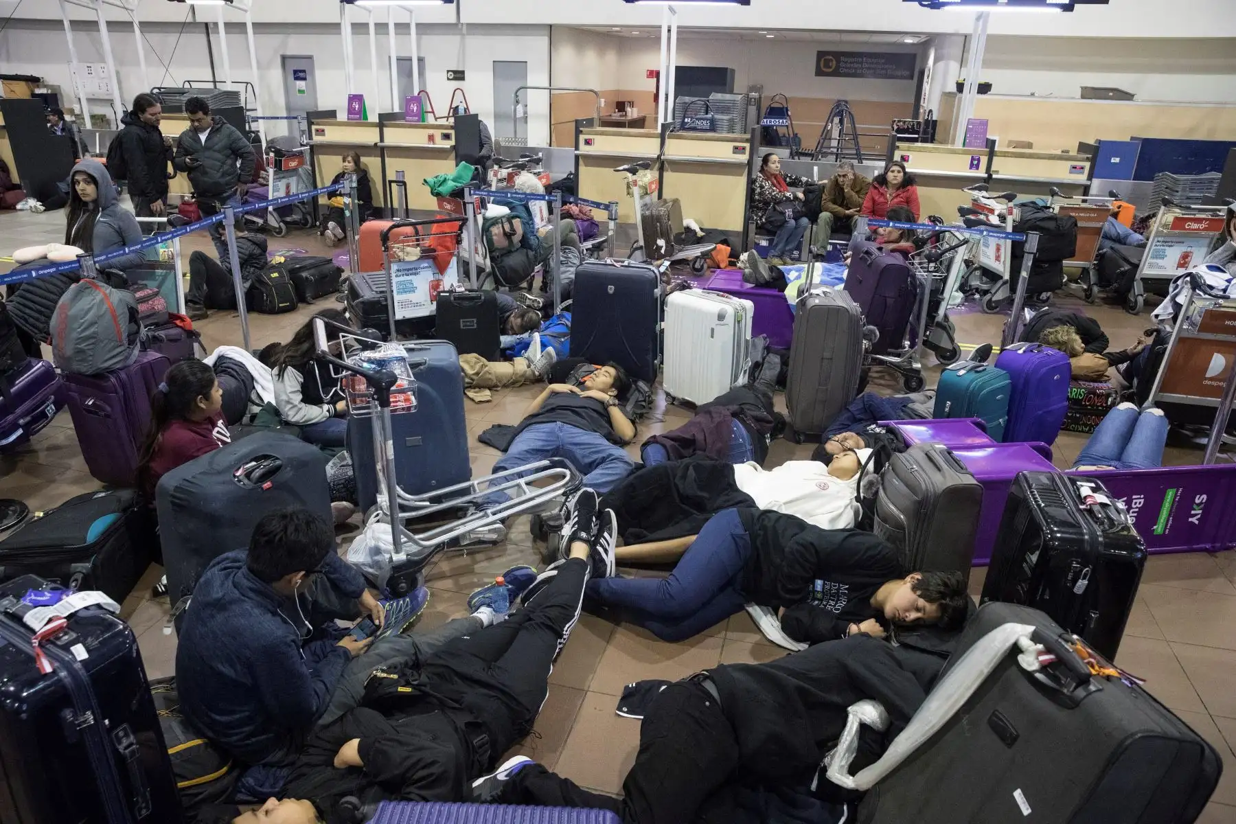 Cientos de pasajeros quedaron atrapados en el aeropuerto de Santiago de Chile tras la cancelación de sus vuelos debido al toque de queda decretado en la capital chilena por las violentas protestas. Foto: EFE