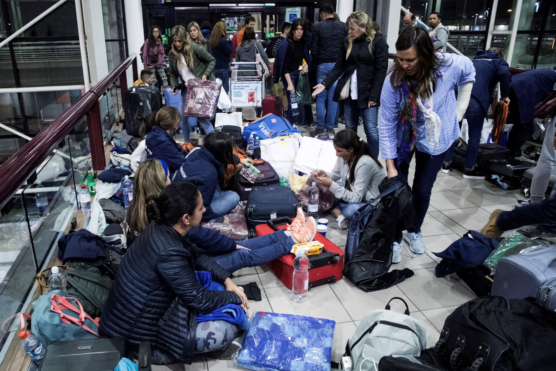 Cientos de pasajeros quedaron atrapados en el aeropuerto de Santiago de Chile tras la cancelación de sus vuelos debido al toque de queda decretado en la capital chilena por las violentas protestas. Foto: EFE