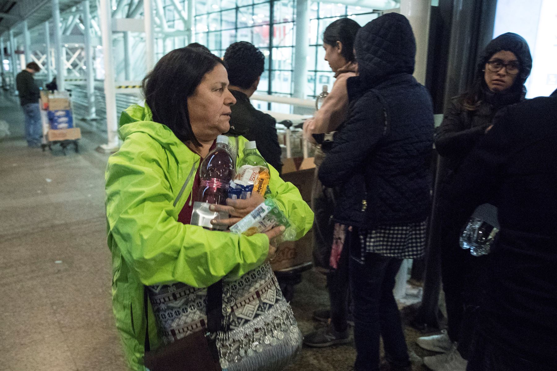 Voluntarios y trabajadores del aeropuerto de Santiago reparten agua y comida a los cientos de pasajeros que permanecen varados después de la masiva suspensión de vuelos. Foto: EFE